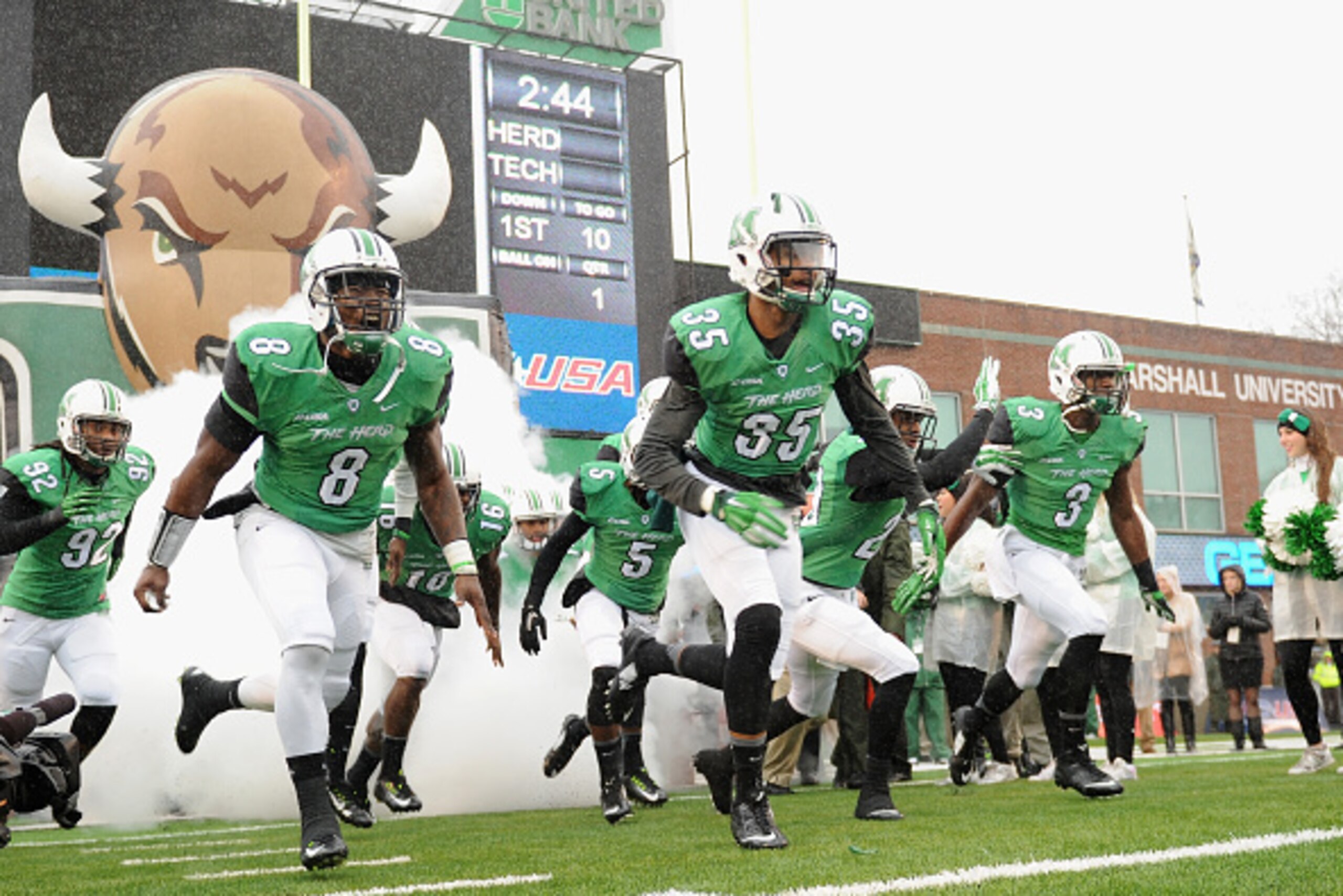 HUNTINGTON, WV - DECEMBER 06: Remi Watson #8, Kevin Rodriguez #35, and Stefan Houston #3 of the Marshall Thundering Herd take the field before their game against the Louisiana Tech Bulldogs at Joan C. Edwards Stadium during the Conference USA championship