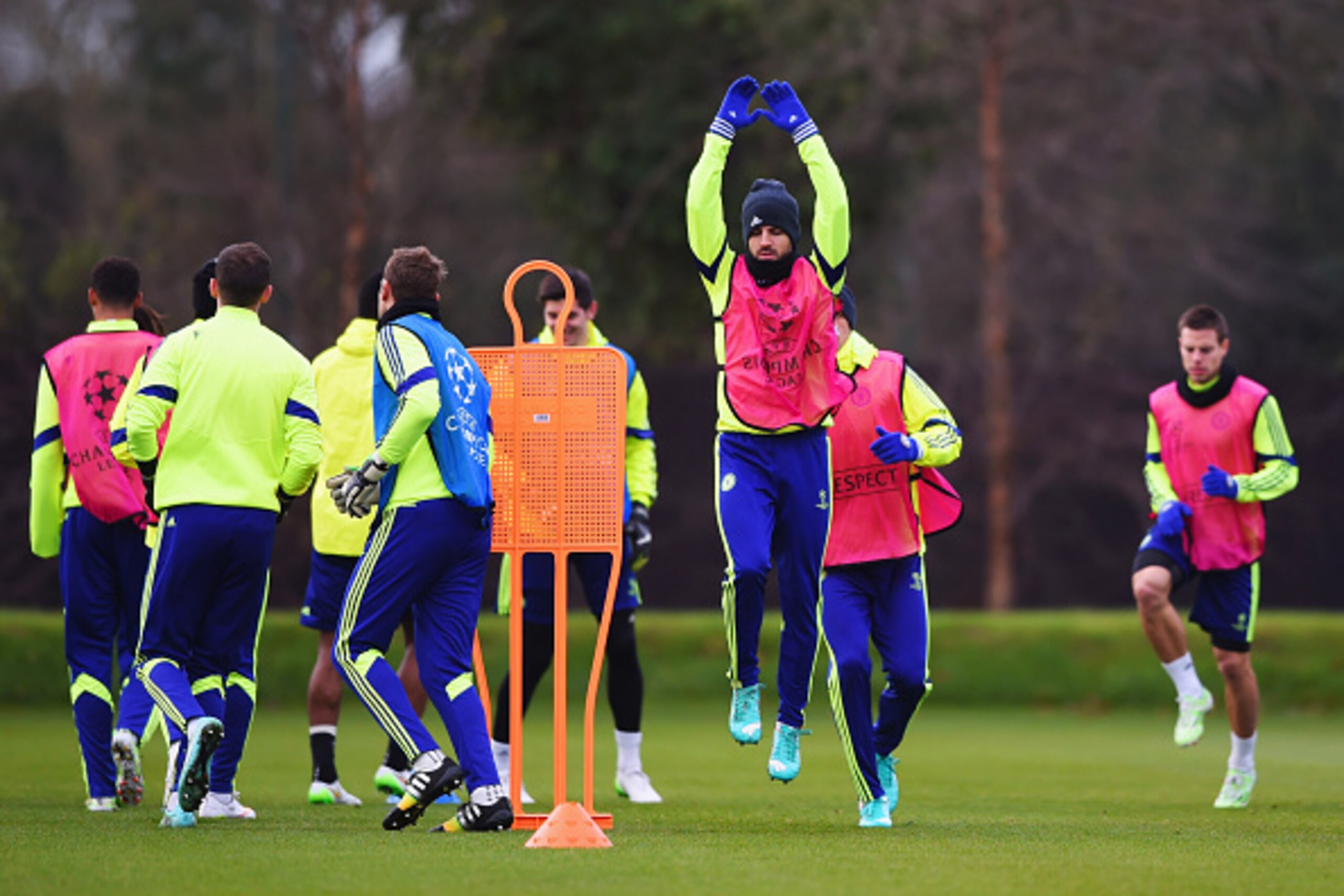 LONDON, ENGLAND - DECEMBER 09:  Cesc Fabregas (3R) warms up alongside team  mates during a Chelsea training session, ahead of the UEFA Champions League Group G match, against Sporting Clube de Portugal at Cobham Training Centre on December 9, 2014 in Lond
