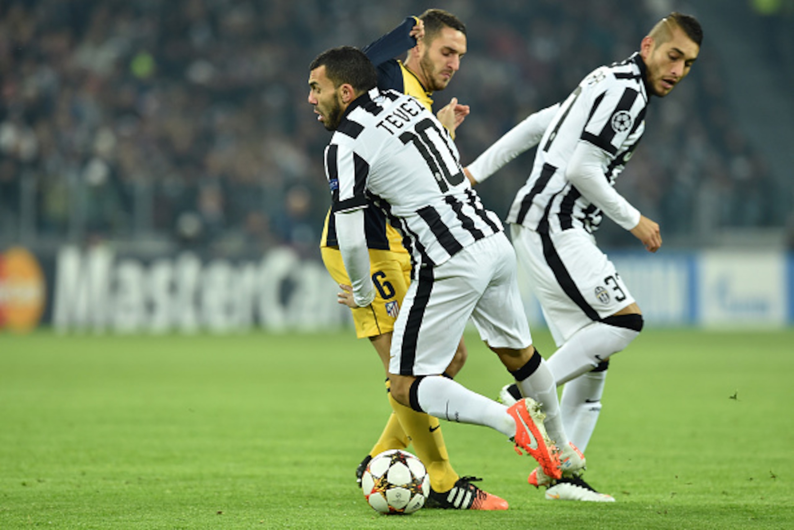 TURIN, ITALY - DECEMBER 09:  Carlos Tevez (R) of Juventus clashes with Koke of Club Atletico de Madrid during the UEFA Champions League group A match between Juventus and Club Atletico de Madrid at Juventus Arena on December 9, 2014 in Turin, Italy.  (Pho