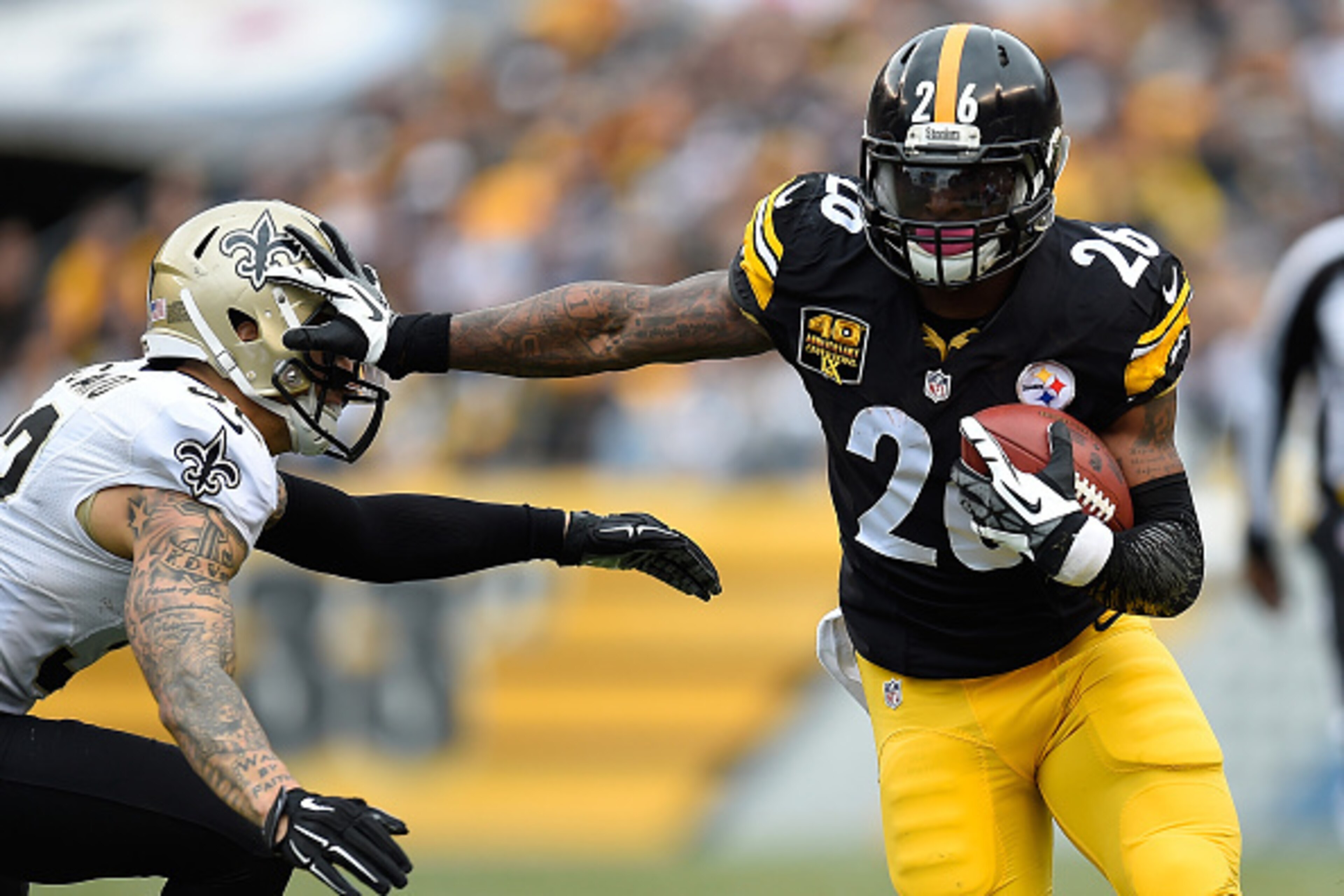 PITTSBURGH, PA - NOVEMBER 30:  Le'Veon Bell #26 of the Pittsburgh Steelers stiff arms Kenny Vaccaro #32 of the New Orleans Saints during the first quarter at Heinz Field on November 30, 2014 in Pittsburgh, Pennsylvania.  (Photo by Joe Sargent/Getty Images