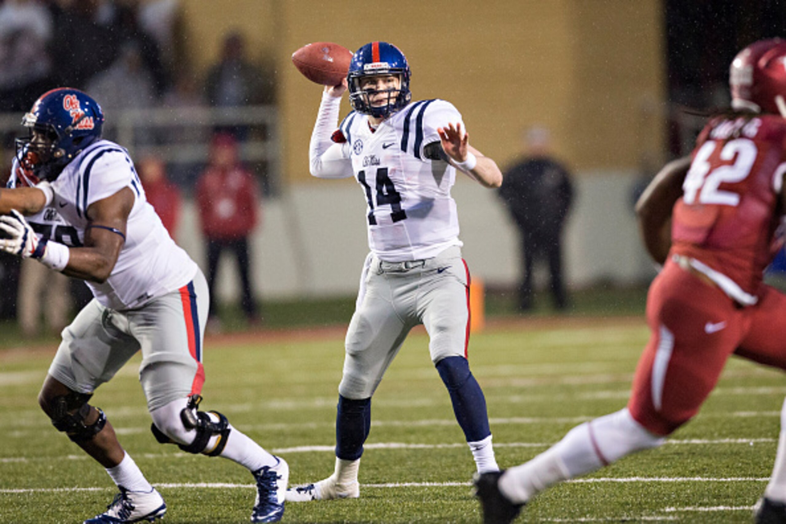 FAYETTEVILLE, AR - NOVEMBER 22:  Bo Wallace #14 of the Ole Miss Rebels throws a pass in the fourth quarter against the Arkansas Razorbacks at Razorback Stadium on November 22, 2014 in Fayetteville, Arkansas.  The Razorbacks defeated the Rebels 30-0.  (Pho