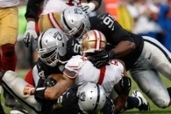 Dec 7, 2014; Oakland, CA, USA; Oakland Raiders outside linebacker Khalil Mack (52), defensive tackle Antonio Smith (94) and defensive end Justin Tuck (91) sack San Francisco 49ers quarterback Colin Kaepernick (7) during the fourth quarter at O.co Coliseum