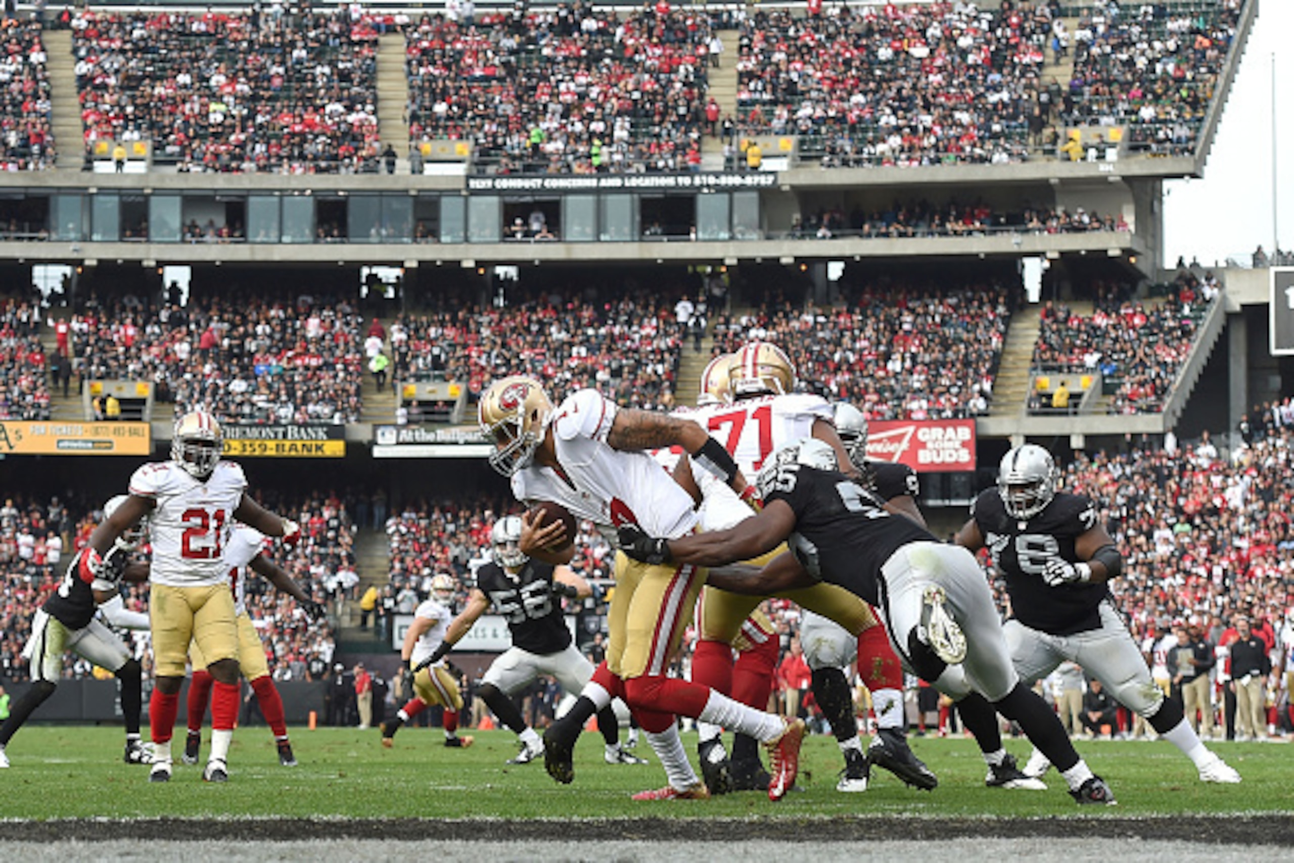 OAKLAND, CA - DECEMBER 07:  Sio Moore #55 of the Oakland Raiders gets a hold of Colin Kaepernick #7 of the San Francisco 49ers in the second quarter at O.co Coliseum on December 7, 2014 in Oakland, California.  (Photo by Thearon W. Henderson/Getty Images)