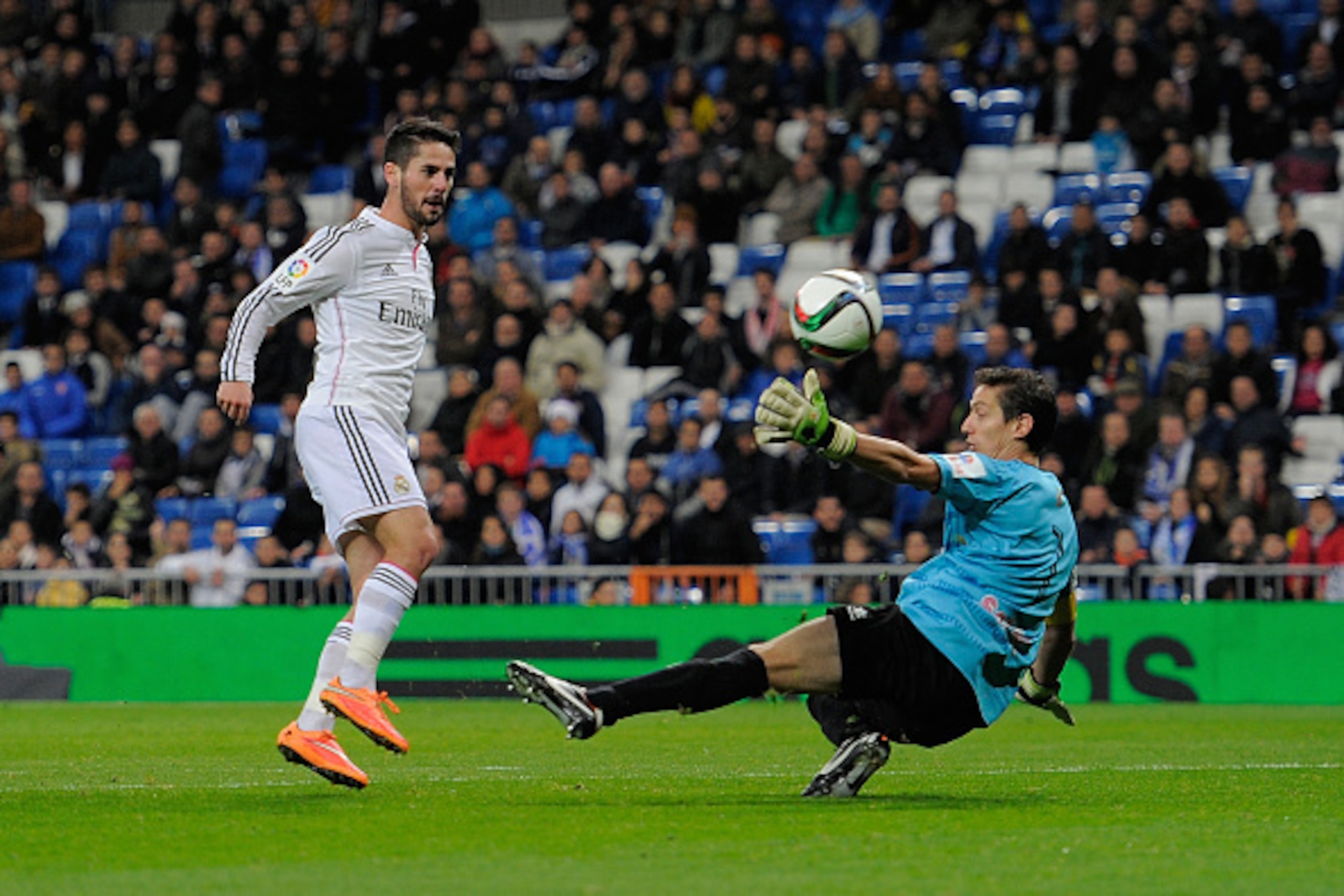 MADRID, SPAIN - DECEMBER 02:  Isco of Real Madrid CF lobs the ball over Inigo Romera to score Real's 2nd goal during the Copa Del Rey Round of 32, Second Leg match between Real Madrid CF and Cornella at Santiago Bernabeu stadium on December 2, 2014 in Mad