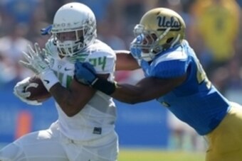 Oct 11, 2014; Pasadena, CA, USA; Oregon Ducks running back Thomas Tyner (24) is defended by UCLA Bruins linebacker Kenny Young (42) at Rose Bowl. Mandatory Credit: Kirby Lee-USA TODAY Sports