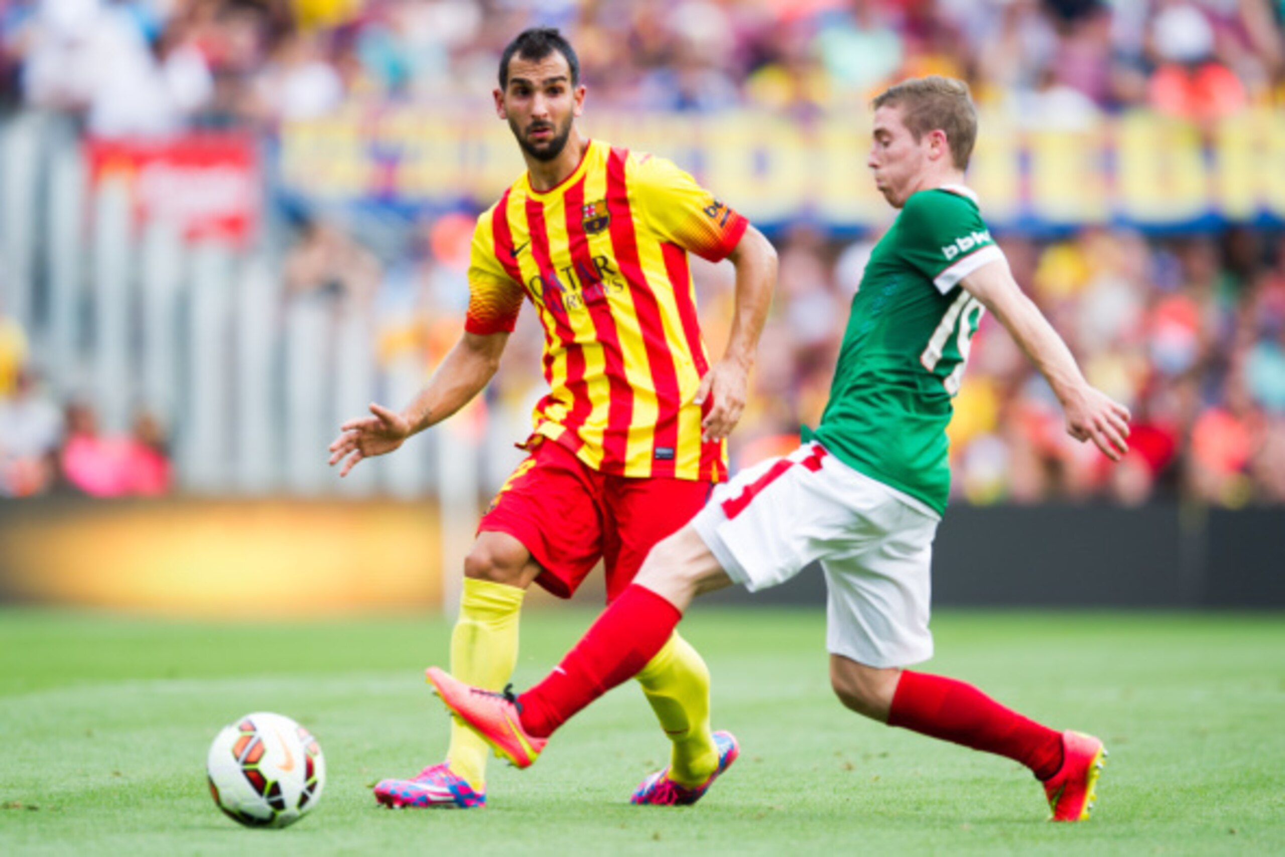 BARCELONA, SPAIN - SEPTEMBER 13: Martin Montoya (L) of FC Barcelona and Iker Muniain of Athletic Club compete for the ball during the La Liga match between FC Barcelona and Athletic Club at Camp Nou on September 13, 2014 in Barcelona, Spain. (Photo by Ale