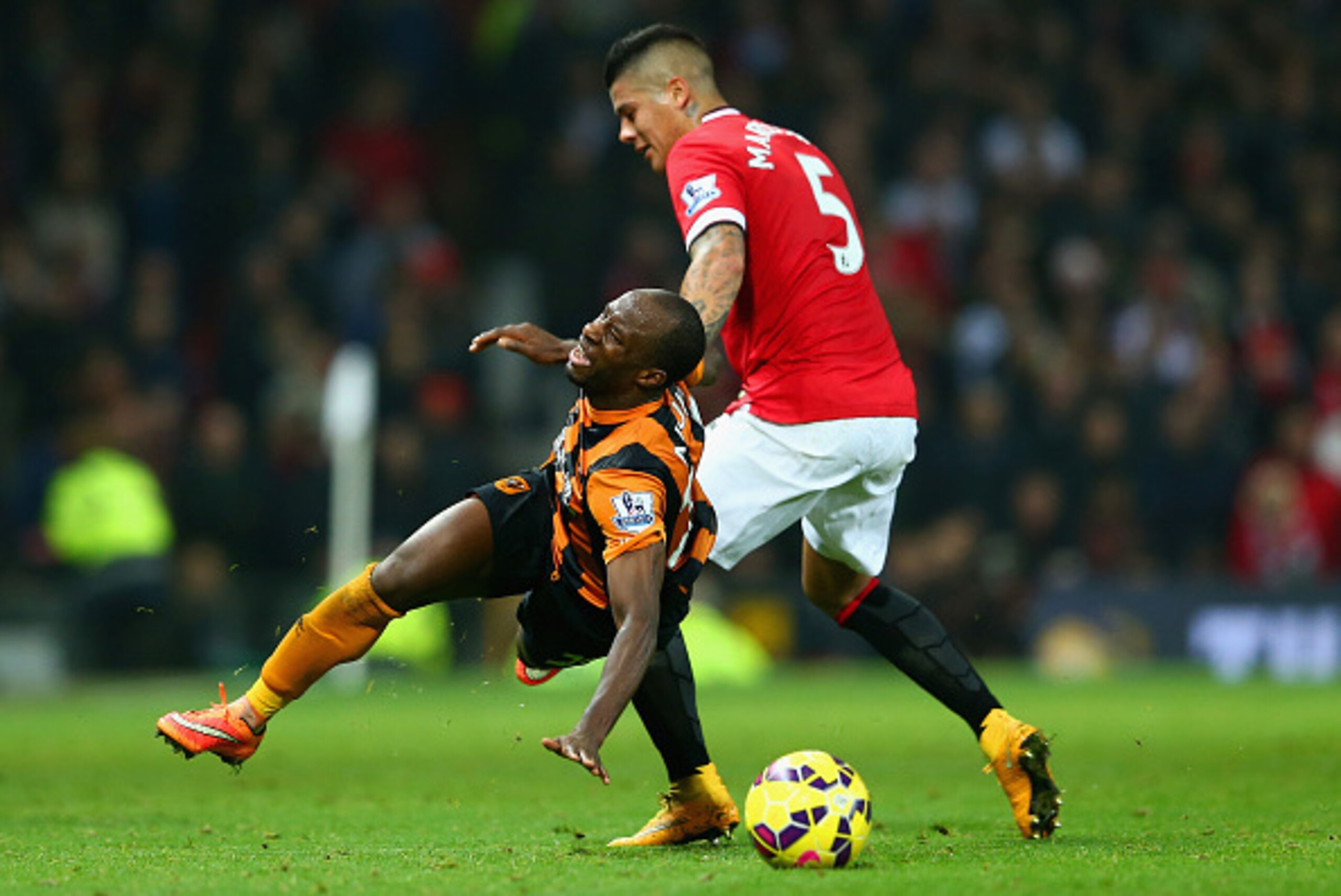 MANCHESTER, ENGLAND - NOVEMBER 29:  Marcos Rojo of Manchester United tackles Sone Aluko of Hull City during the Barclays Premier League match between Manchester United and Hull City at Old Trafford on November 29, 2014 in Manchester, England.  (Photo by M