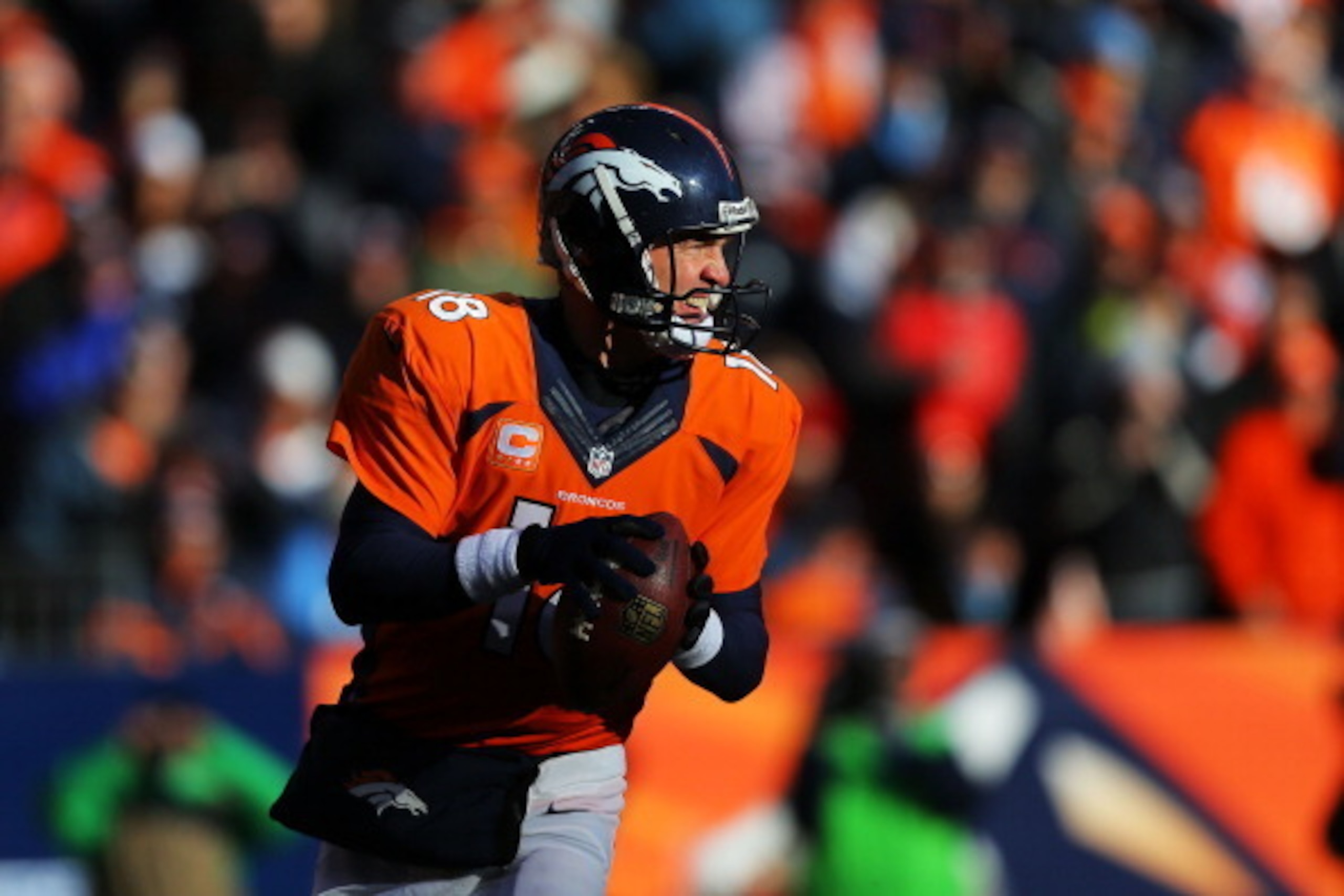 DENVER, CO - JANUARY 12:  Peyton Manning #18 of the Denver Broncos looks to pass against the San Diego Chargers during the AFC Divisional Playoff Game at Sports Authority Field at Mile High on January 12, 2014 in Denver, Colorado.  (Photo by Justin Edmond