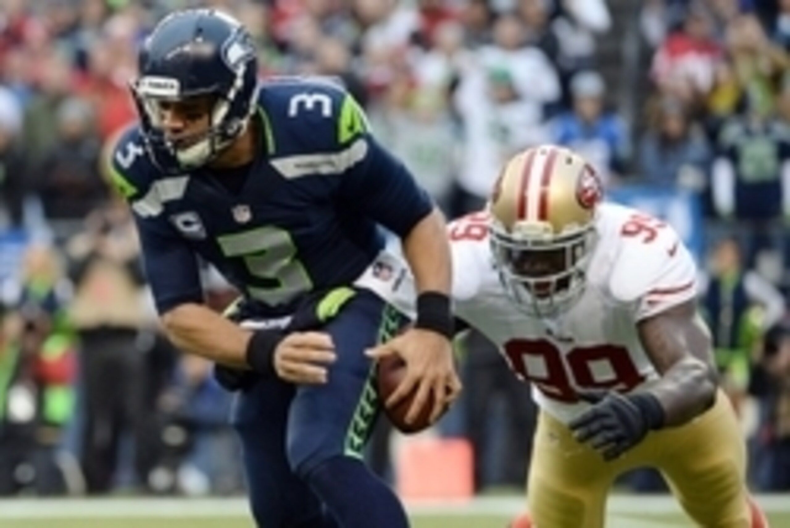 Jan 19, 2014; Seattle, WA, USA; Seattle Seahawks quarterback Russell Wilson (3) fumbles the ball as he is pressured by San Francisco 49ers outside linebacker Aldon Smith (99) during the first half of the 2013 NFC Championship football game at CenturyLink 