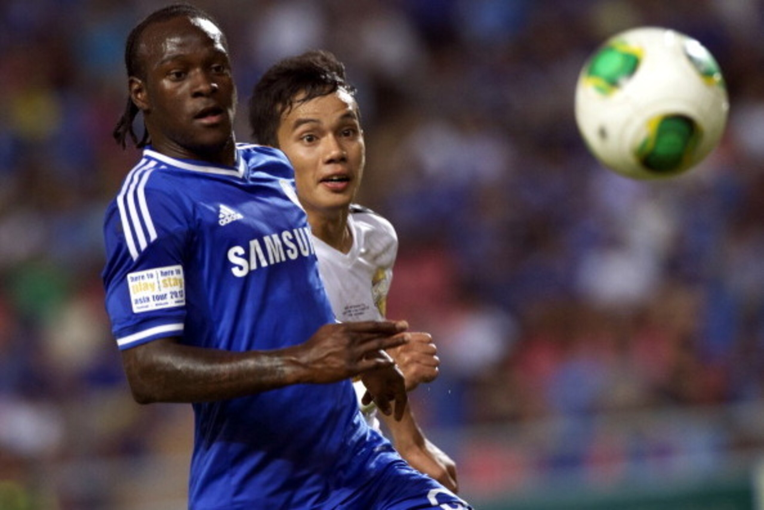 BANGKOK, THAILAND - JULY 17:  Victor Moses of Chelsea is checked by Nattaporn of Singha Thailand All-Star XI during the international friendly match between Chelsea FC and the Singha Thailand All-Star XI at the Rajamangala Stadium in Bangkok, Thailand on 