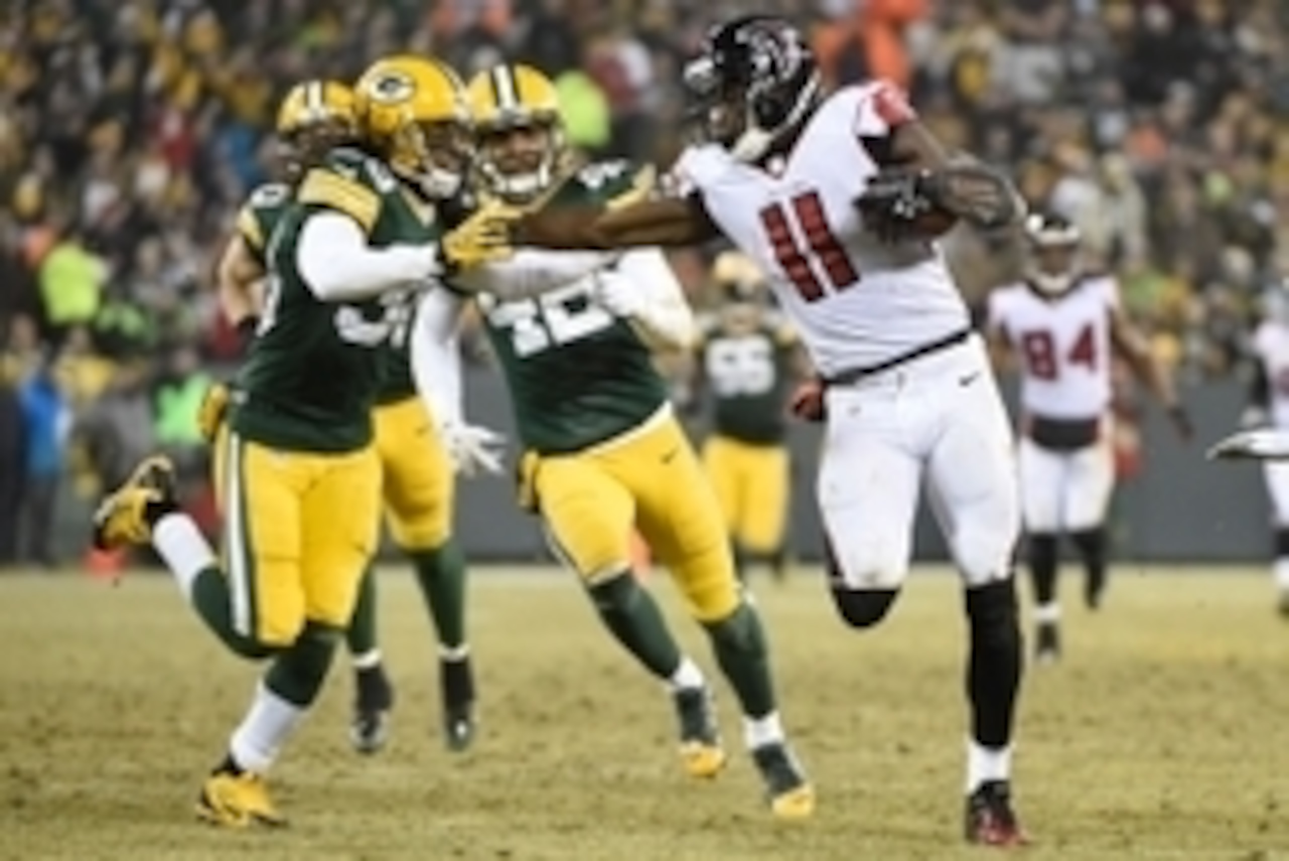 Dec 8, 2014; Green Bay, WI, USA;  Atlanta Falcons wide receiver Julio Jones (11) tries to break away from Green Bay Packers cornerback Tramon Williams (38) after catching a pss in the third quarter at Lambeau Field. Mandatory Credit: Benny Sieu-USA TODAY 