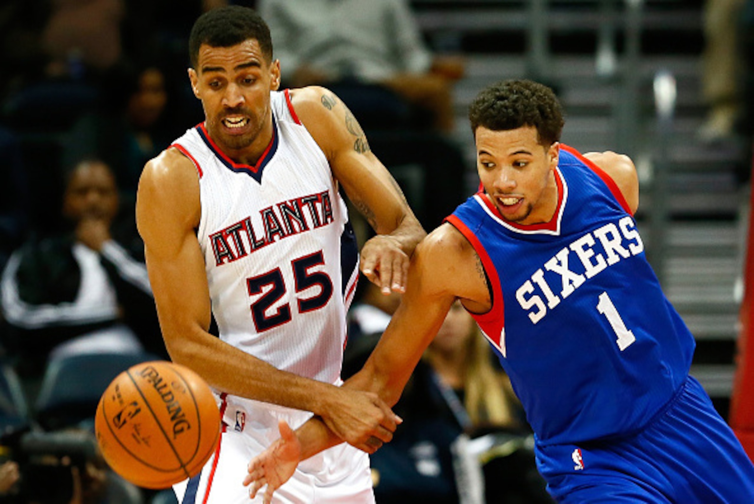 ATLANTA, GA - DECEMBER 10:  Thabo Sefolosha #25 of the Atlanta Hawks and Michael Carter-Williams #1 of the Philadelphia 76ers battle for a loose ball at Philips Arena on December 10, 2014 in Atlanta, Georgia.  NOTE TO USER: User expressly acknowledges and