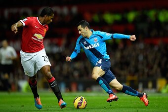 MANCHESTER, ENGLAND - DECEMBER 02:  Oussama Assaidi of Stoke City competes with Antonio Valencia of Manchester United during the Barclays Premier League match between Manchester United and Stoke City at Old Trafford on December 2, 2014 in Manchester, Engl