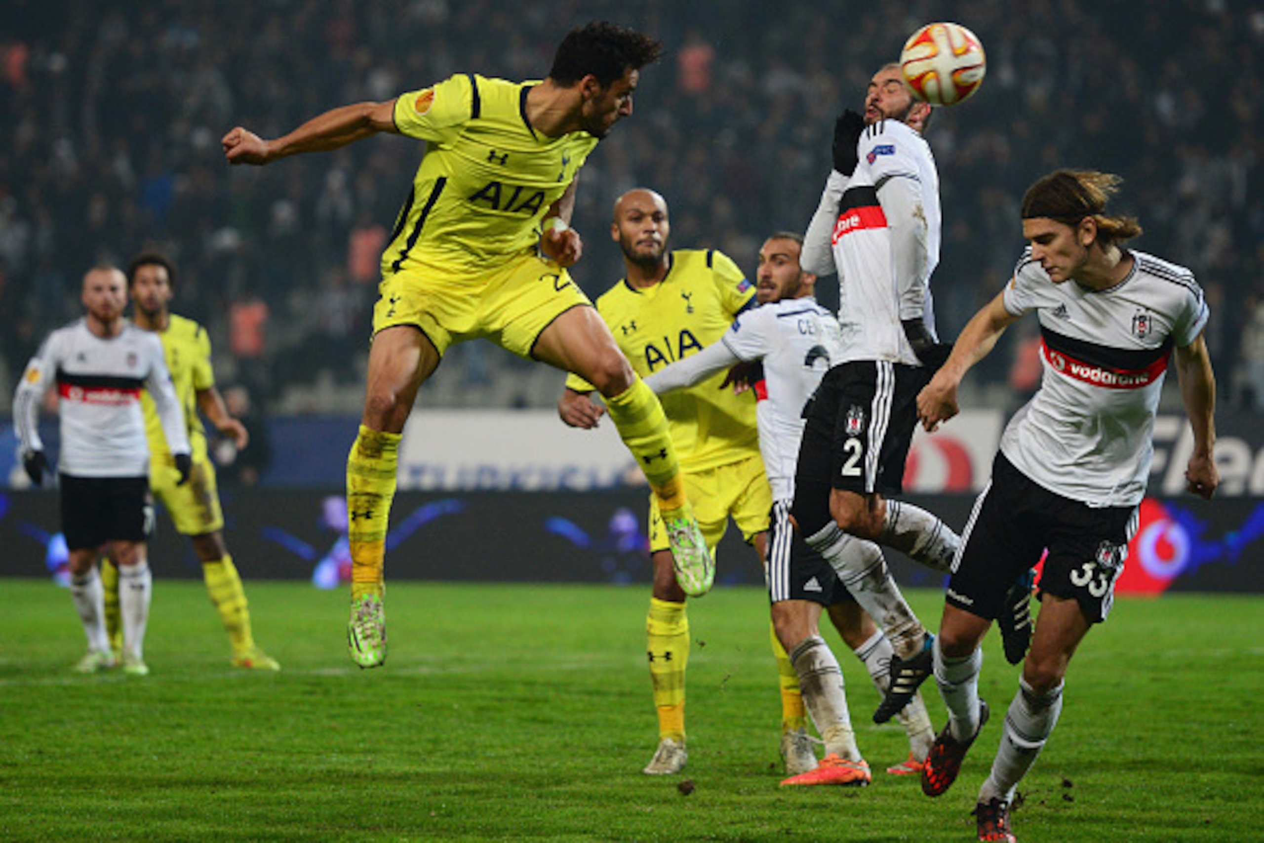 ISTANBUL, TURKEY - DECEMBER 11:  Nacer Chadli of Spurs (L) heads at goal past Serdar Kurtulus (2) and Atinc Nukan of Besiktas (33) during the UEFA Europa League Group C match between Besiktas JK and Tottenham Hotspur FC at Ataturk Olympic Stadium on Decem