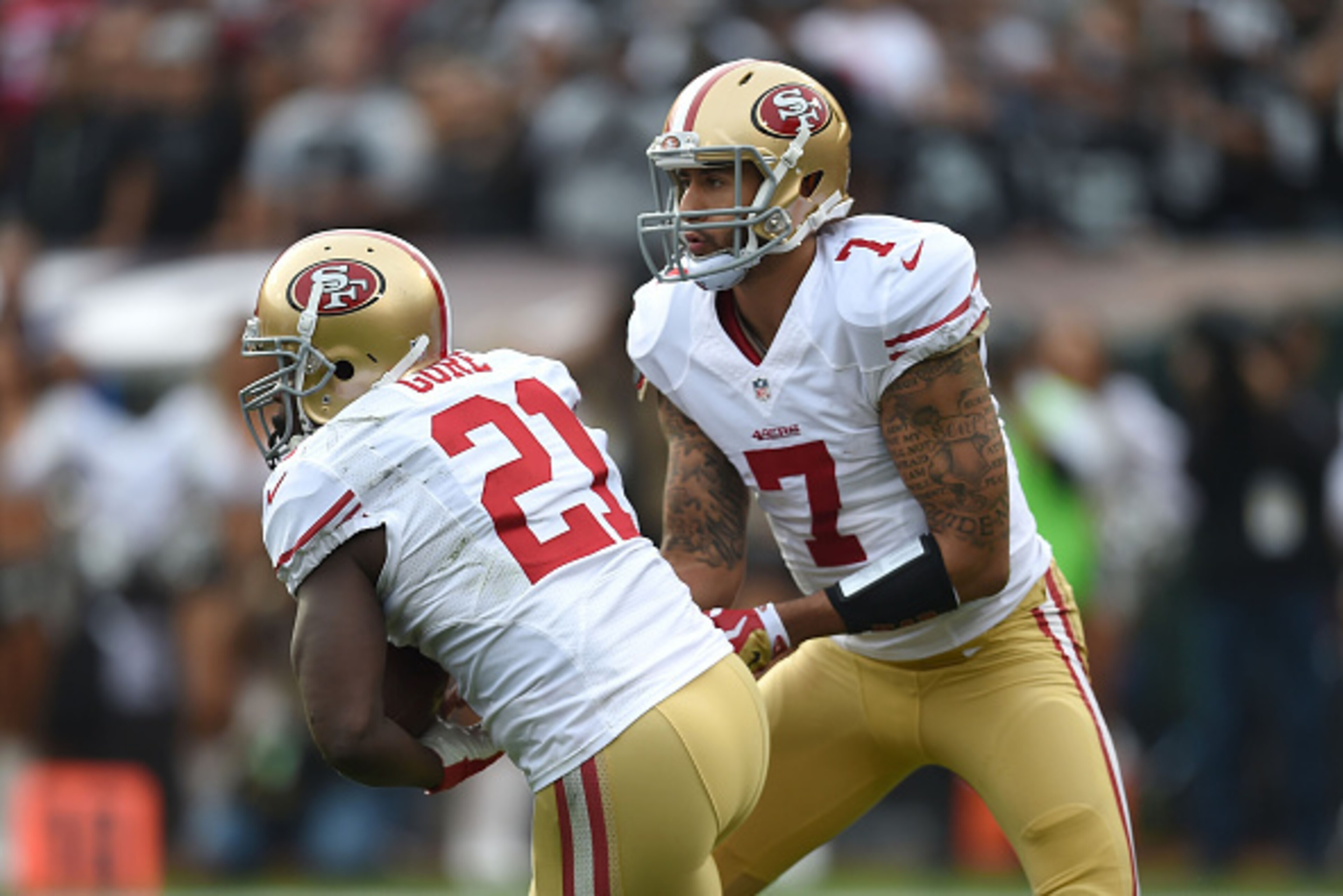 OAKLAND, CA - DECEMBER 07:  Colin Kaepernick #7 of the San Francisco 49ers hands off to Frank Gore #21 of the San Francisco 49ers against the Oakland Raiders in the first quarter at O.co Coliseum on December 7, 2014 in Oakland, California.  (Photo by Thea