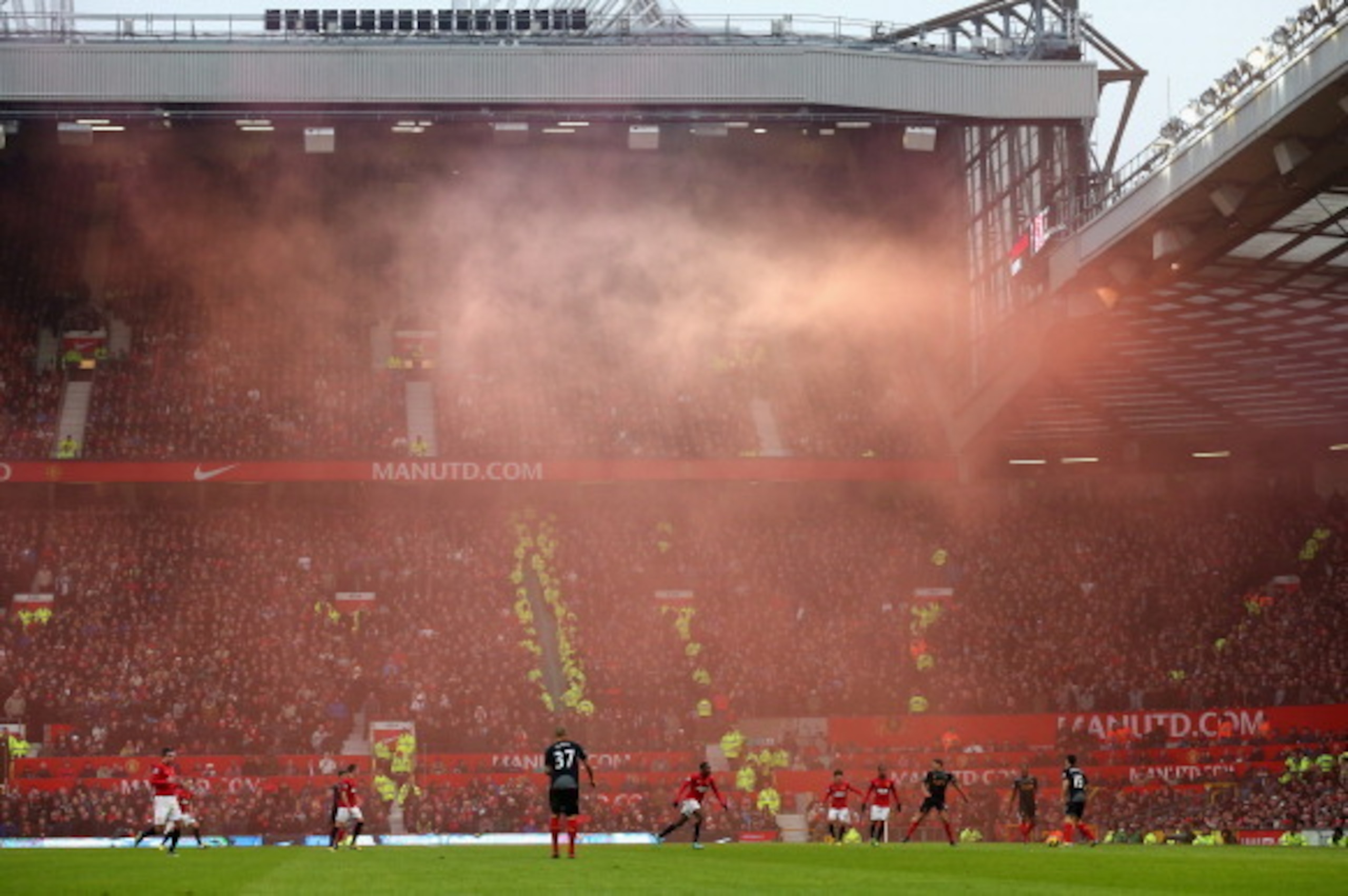 MANCHESTER, ENGLAND - JANUARY 13: General View as smoke from a flare drifts across the pitch during the Barclays Premier League match between Manchester United and Liverpool at Old Trafford on January 13, 2013 in Manchester, England. (Photo by Alex Lives MANCHESTER, ENGLAND - JANUARY 13: General View as smoke from a flare drifts across the pitch during the Barclays Premier League match between Manchester United and Liverpool at Old Trafford on January 13, 2013 in Manchester, England. (Photo by Alex Lives