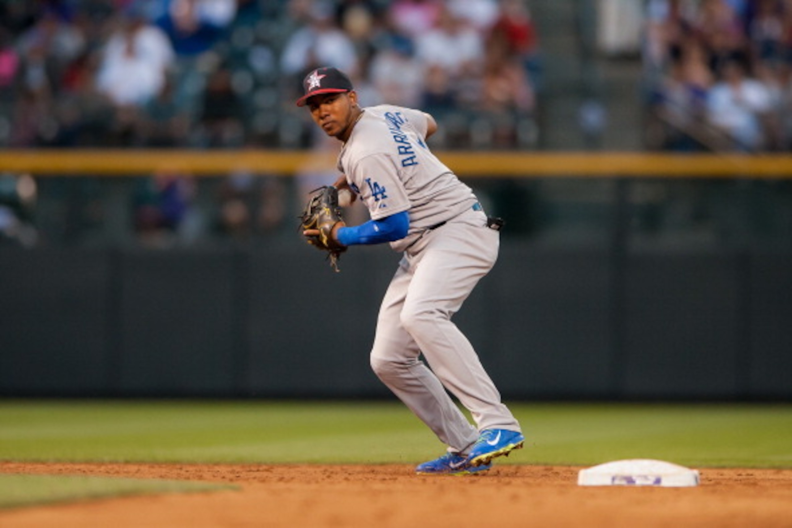 DENVER, CO - JULY 4:  Erisbel Arruebarrena #11 of the Los Angeles Dodgers sets to throw to first base for a putout against the Colorado Rockies at Coors Field on July 4, 2014 in Denver, Colorado. The Dodgers beat the Rockies 9-0. (Photo by Dustin Bradford