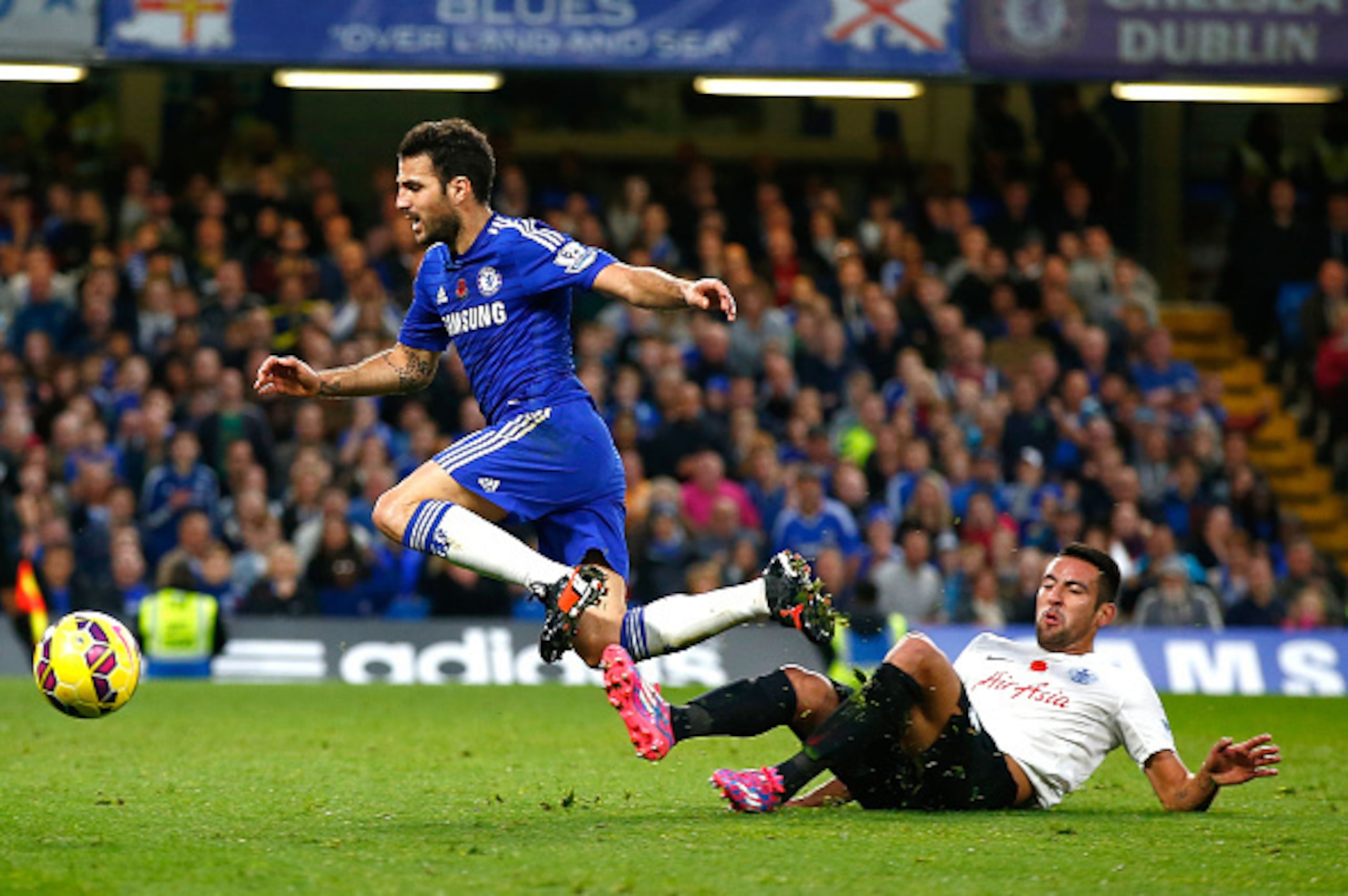 LONDON, ENGLAND - NOVEMBER 01:  Mauricio Isla of Queens Park Rangers tackles Cesc Fabregas of Chelsea during the Barclays Premier League match between Chelsea and Queens Park Rangers at Stamford Bridge on November 1, 2014 in London, England.  (Photo by Cl