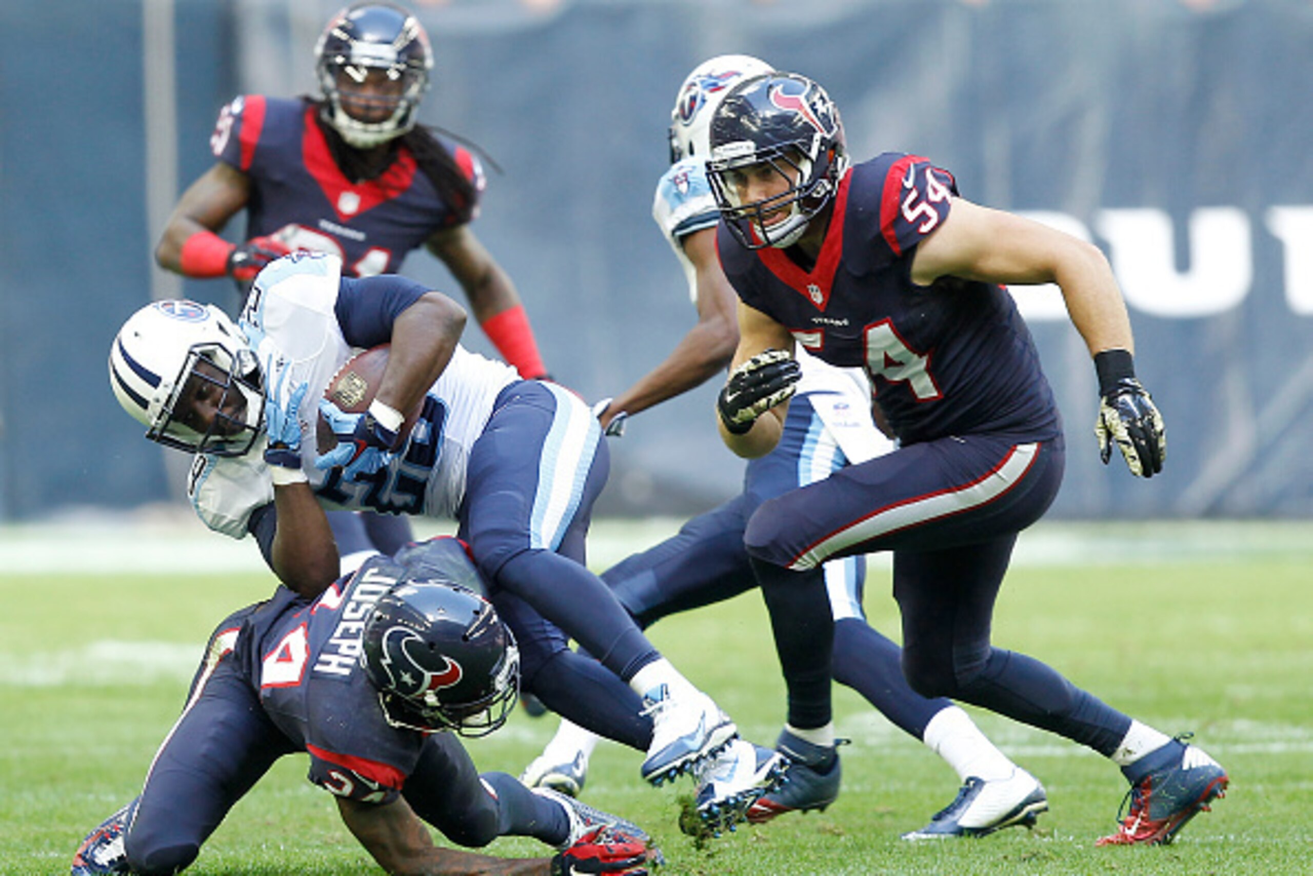 HOUSTON, TX - NOVEMBER 30: Bishop Sankey #20 of the Tennessee Titans is tackled by Johnathan Joseph #24 of the Houston Texans in the second quarter in a NFL game on November 30, 2014 at NRG Stadium in Houston, Texas. (Photo by Bob Levey/Getty Images)