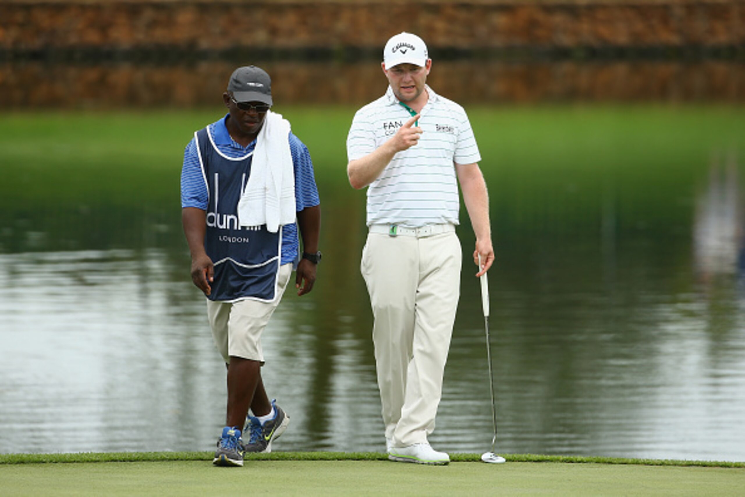 MALELANE, SOUTH AFRICA - DECEMBER 12:  Branden Grace of South Africa with his caddy Zack Rasego during the second round of the Alfred Dunhill Championship at Leopard Creek Country Golf Club on December 12, 2014 in Malelane, South Africa.  (Photo by Richar