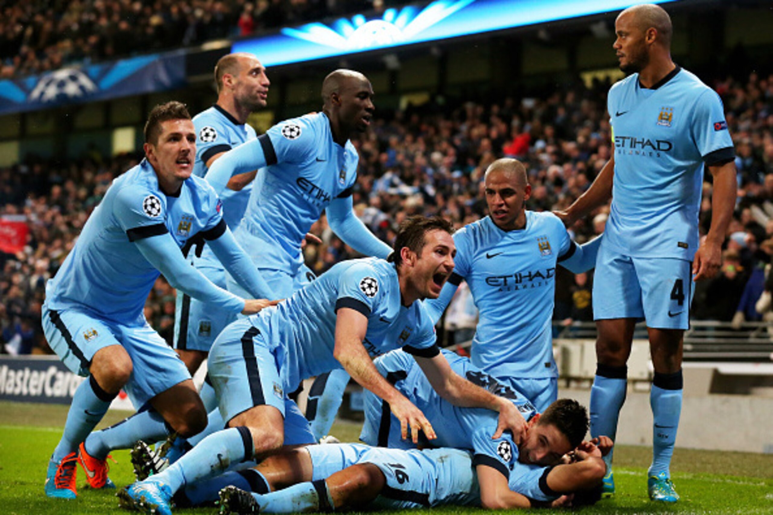MANCHESTER, ENGLAND - NOVEMBER 25:  Sergio Aguero #16 (on ground) of Manchester City celebrates with teammates after scoring his team's third and matchwinning goal during the UEFA Champions League Group E match between Manchester City and FC Bayern Muench