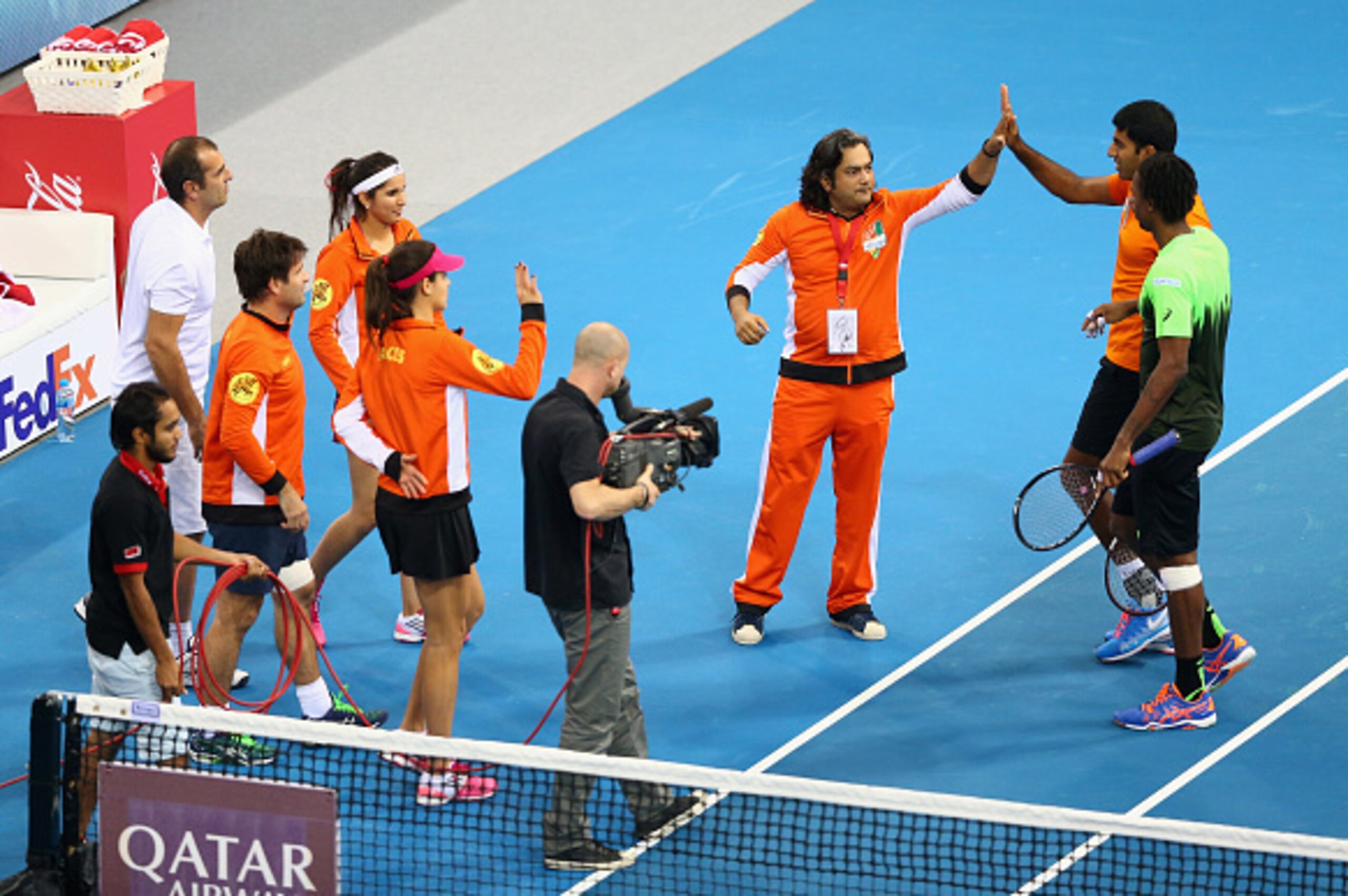 DUBAI, UNITED ARAB EMIRATES -DECEMBER12: Gael Monfils and Rohan Bopanna of the Indian Aces are congratulated by their team bench after their victory against Jo-Wilfried Tsonga and Daniel Nestor of the Manila Mavericks during the Coca-Cola International Pr