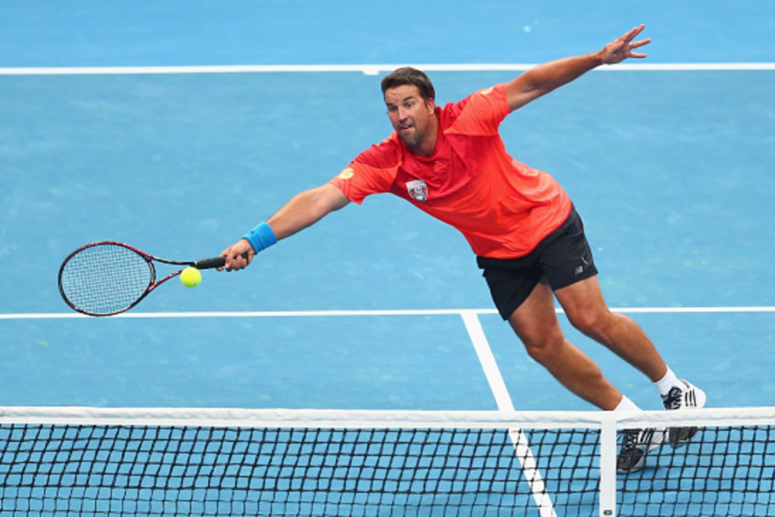 MANILA, PHILIPPINES - NOVEMBER 29: Pat Rafter of the Singapore Slammers plays a volley at the net against Goran Ivanisevic of the UAE Royals during the Coca-Cola International Premier Tennis League at the Mall of Asia Arena on November 29, 2014 in Manila,