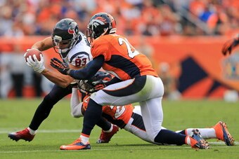 DENVER, CO - SEPTEMBER 23:  Wide receiver Kevin Walter #83 of the Houston Texans makes a pass reception as strong safety Chris Harris #25 of the Denver Broncos makes the tackle and strong safety Mike Adams #20 of the Denver Broncos follows the play at Spo