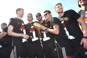BERLIN, GERMANY - JULY 15: Per Mertersacker, Benedikt Hoewedes, Sami Khedira, Mesut Ozil and Ron-Robert Zieler  celebrate during the German team victory ceremony on July 15, 2014 in Berlin, Germany. Germany won the 2014 FIFA World Cup Brazil match against
