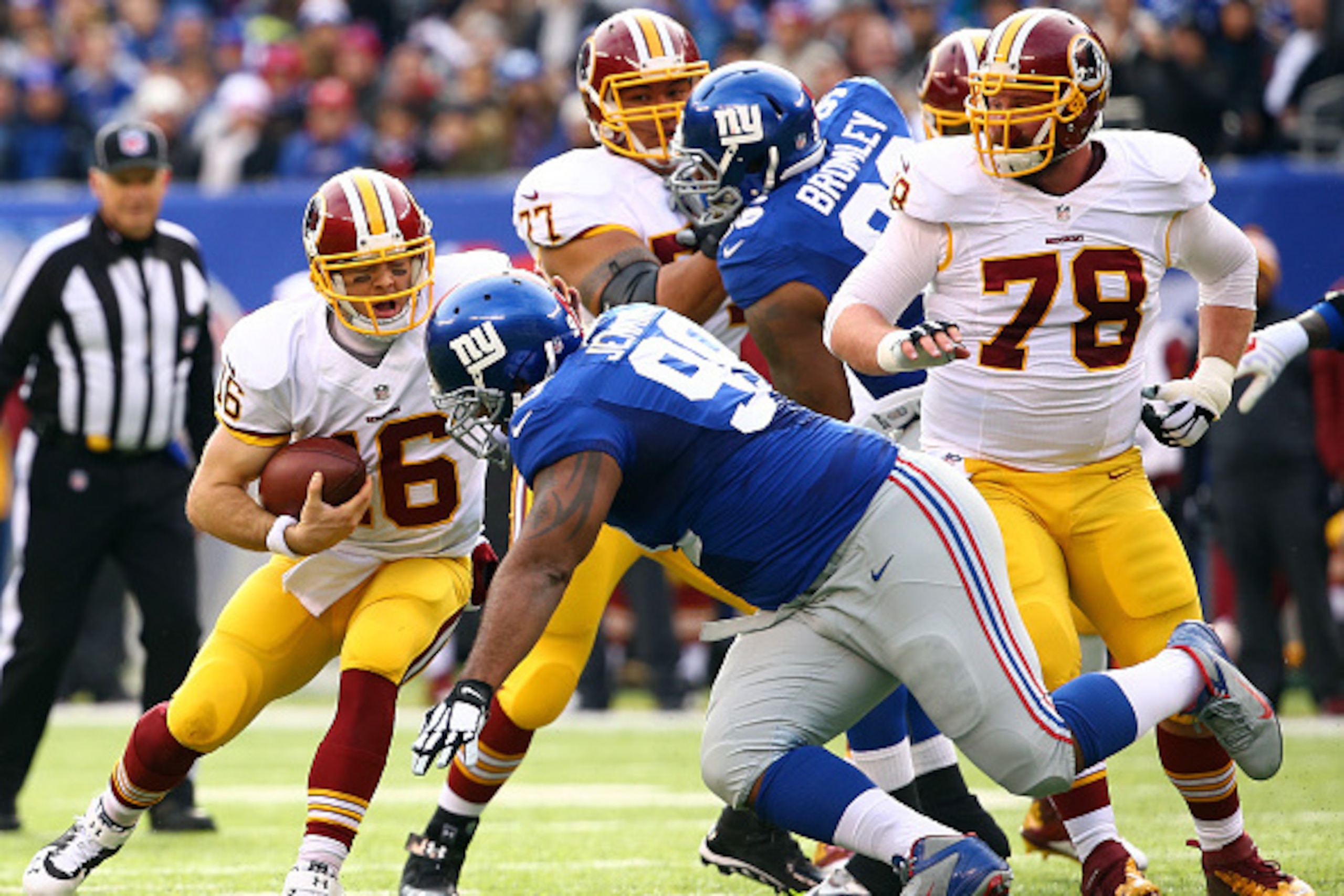 EAST RUTHERFORD, NJ - DECEMBER 14:  Colt McCoy #16 of the Washington Redskins runs the ball in the first quarter against Cullen Jenkins #99 of the New York Giants during their game at MetLife Stadium on December 14, 2014 in East Rutherford, New Jersey.  (