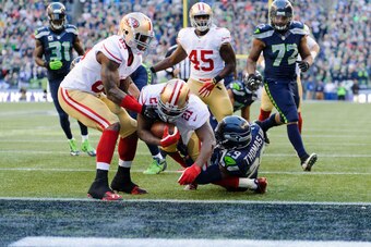 Dec 14, 2014; Seattle, WA, USA; San Francisco 49ers running back Frank Gore (21) breaks a tackle by Seattle Seahawks free safety Earl Thomas (29) to score a touchdown during he first half at CenturyLink Field. Mandatory Credit: Steven Bisig-USA TODAY Spor