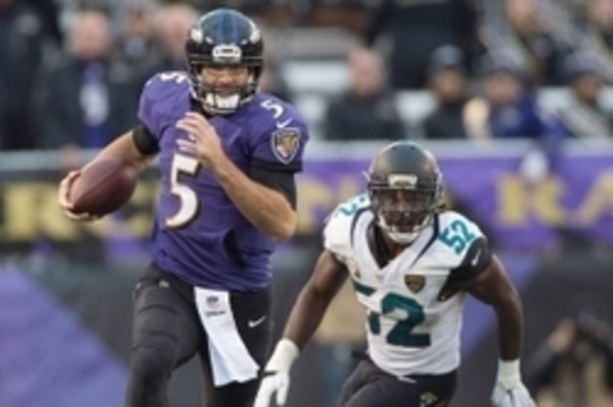 Dec 14, 2014; Baltimore, MD, USA; Baltimore Ravens quarterback Joe Flacco (5) runs past Jacksonville Jaguars middle linebacker J.T. Thomas (52) for a first down during the fourth quarter at M&T Bank Stadium. Baltimore Ravens defeated Jacksonville Jaguars 