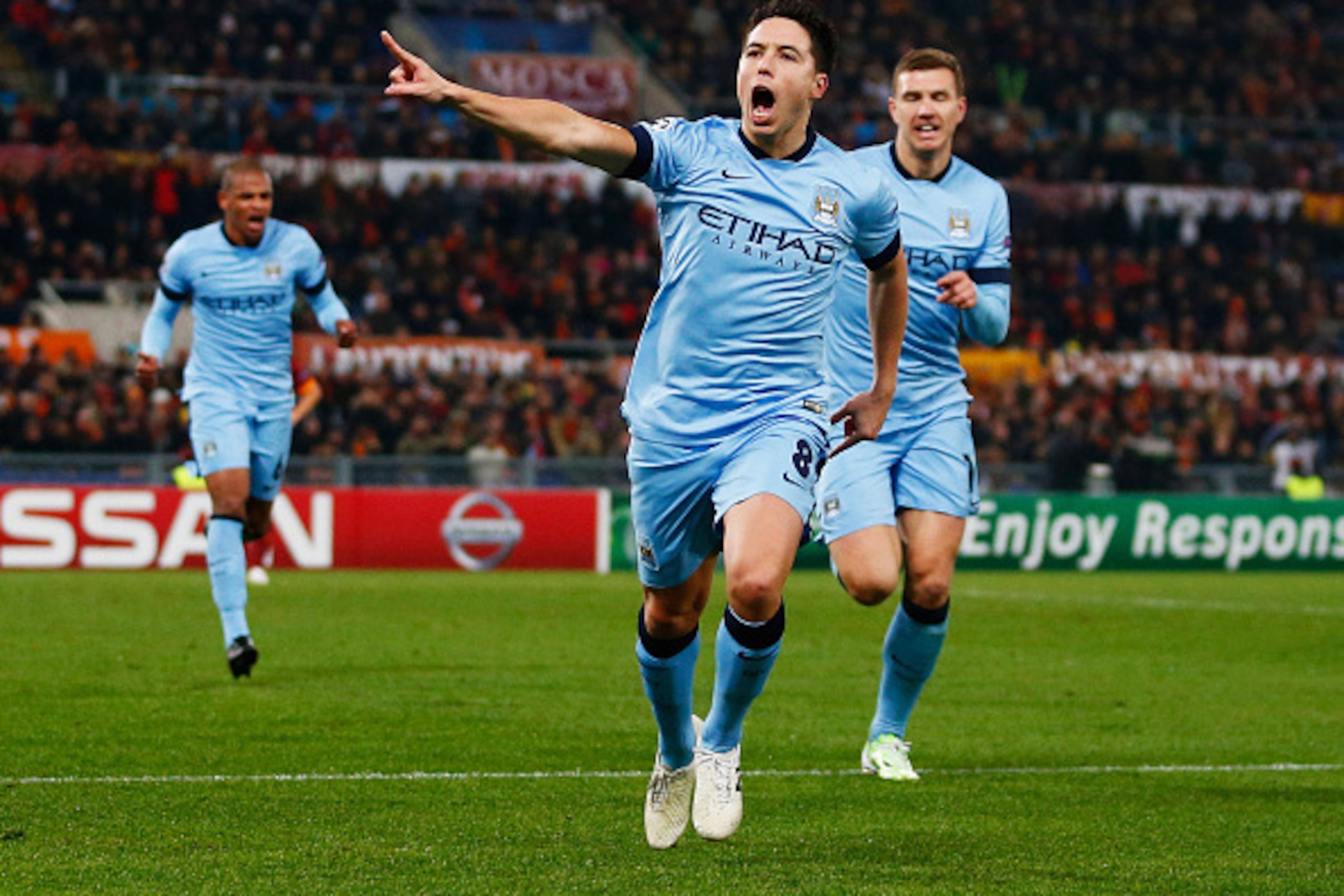 ROME, ITALY - DECEMBER 10:  Samir Nasri of Manchester City (8) celebrates with Edin Dzeko as he scores their first goal during the UEFA Champions League Group E match between AS Roma and Manchester City FC at Stadio Olimpico on December 10, 2014 in Rome, 