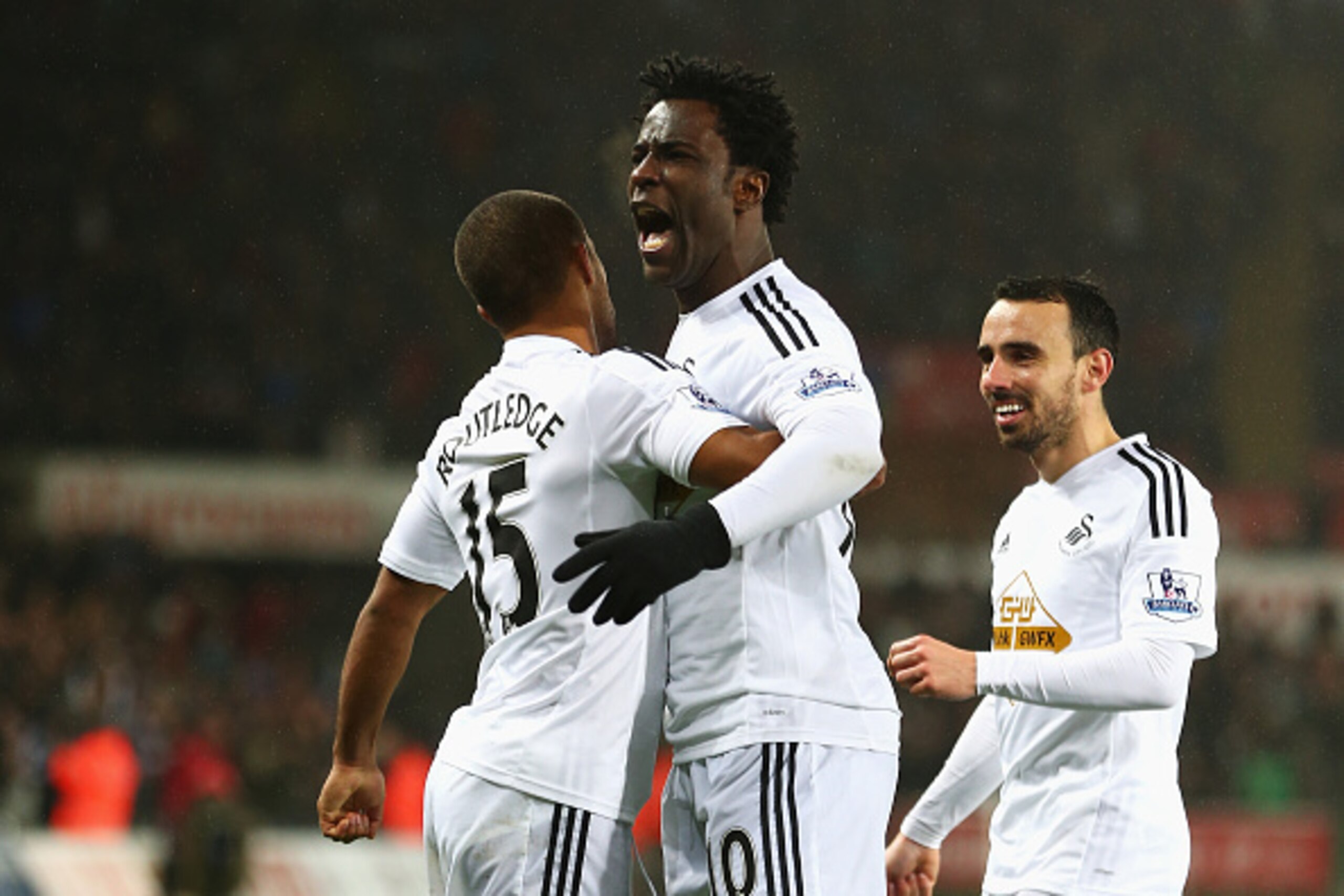 SWANSEA, WALES - DECEMBER 14:  Wilfried Bony (C) of Swansea City celebrates his goal with Wayne Routledge (L) and Leon Britton during the Barclays Premier League match between Swansea City and Tottenham Hotspur at Liberty Stadium on December 14, 2014 in S