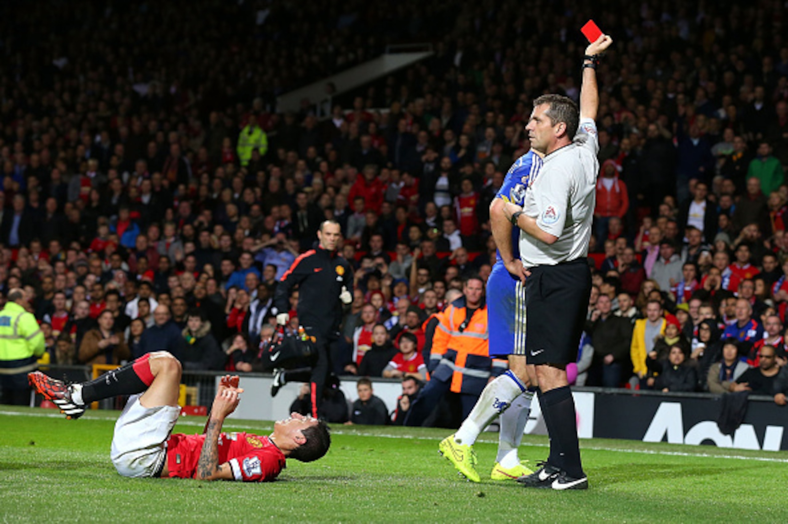 MANCHESTER, ENGLAND - OCTOBER 26:  Referee Phil Dowd shows a red card to Branislav Ivanovic of Chelsea after a challenge on Angel Di Maria of Manchester United during the Barclays Premier League match between Manchester United and Chelsea at Old Trafford 