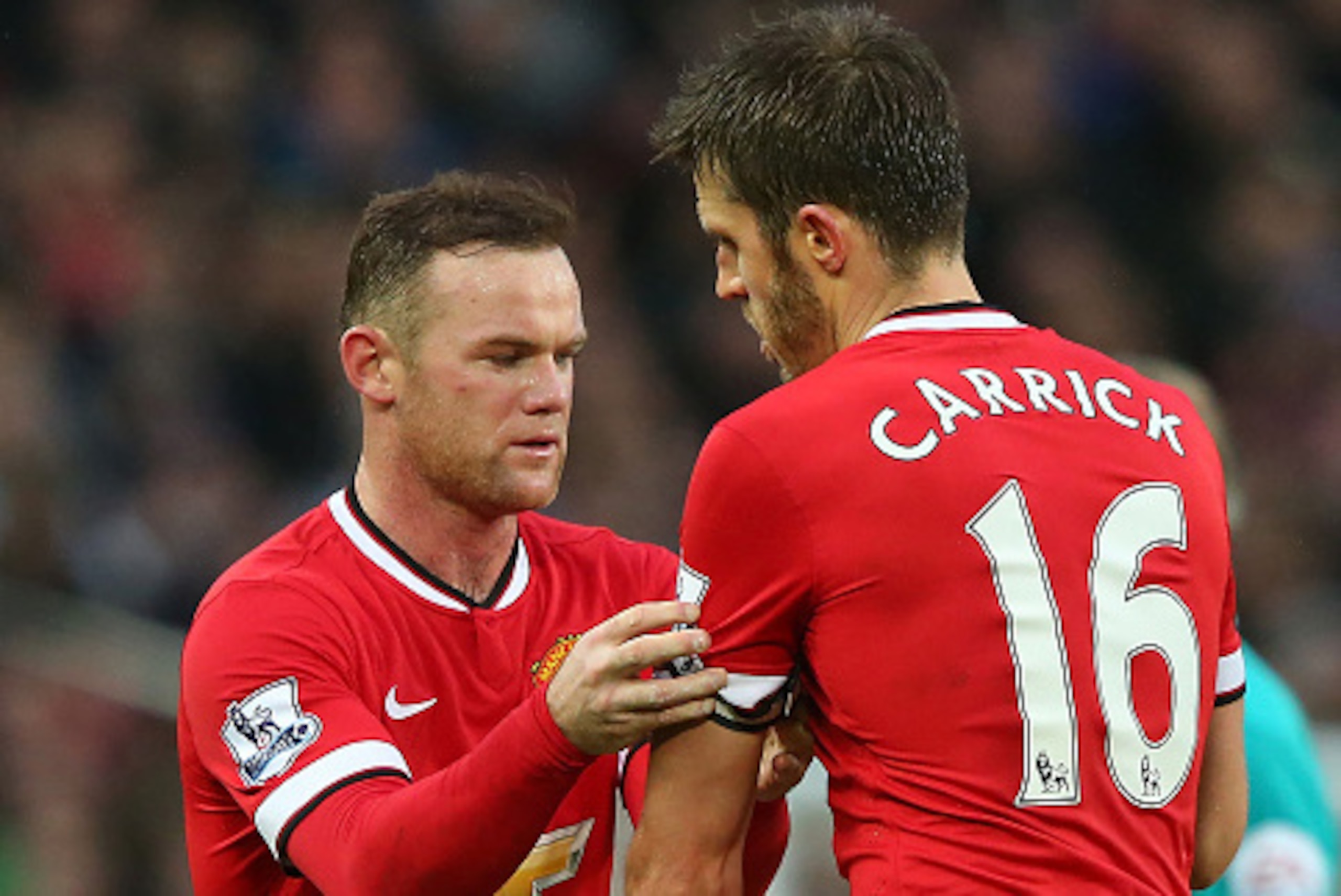 MANCHESTER, ENGLAND - DECEMBER 14:  Wayne Rooney of Manchester United passes the Captain's armband to Michael Carrick during the Barclays Premier League match between Manchester United and Liverpool at Old Trafford on December 14, 2014 in Manchester, Engl