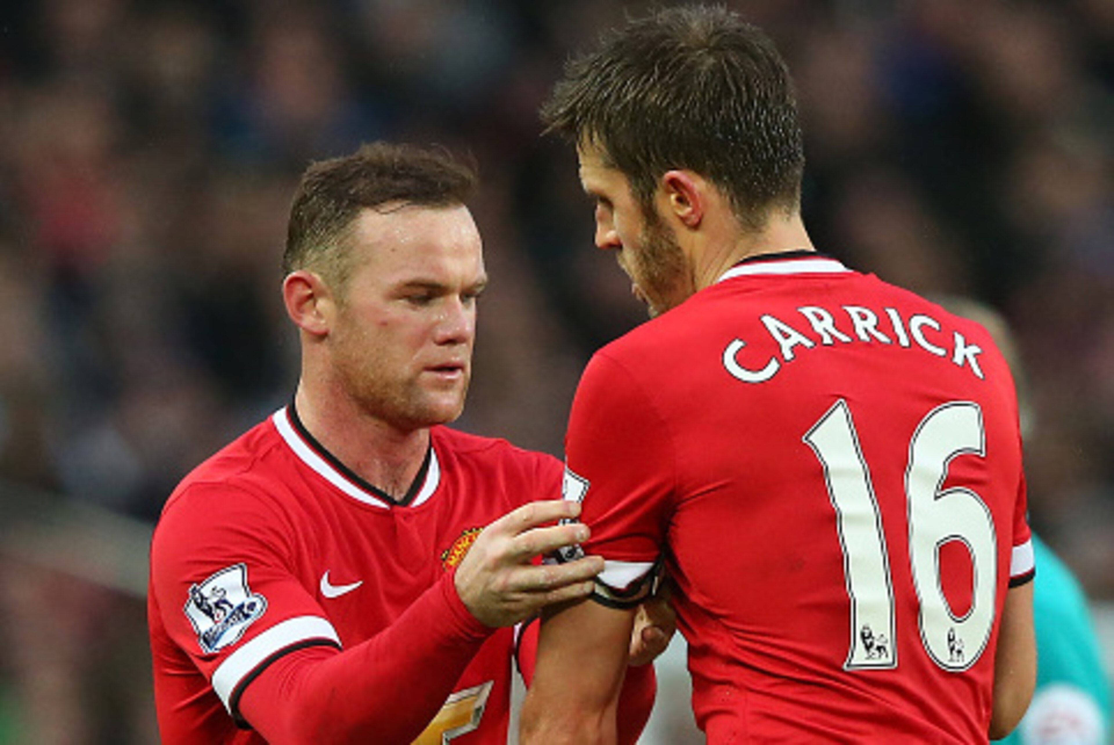 MANCHESTER, ENGLAND - DECEMBER 14:  Wayne Rooney of Manchester United passes the Captain's armband to Michael Carrick during the Barclays Premier League match between Manchester United and Liverpool at Old Trafford on December 14, 2014 in Manchester, Engl