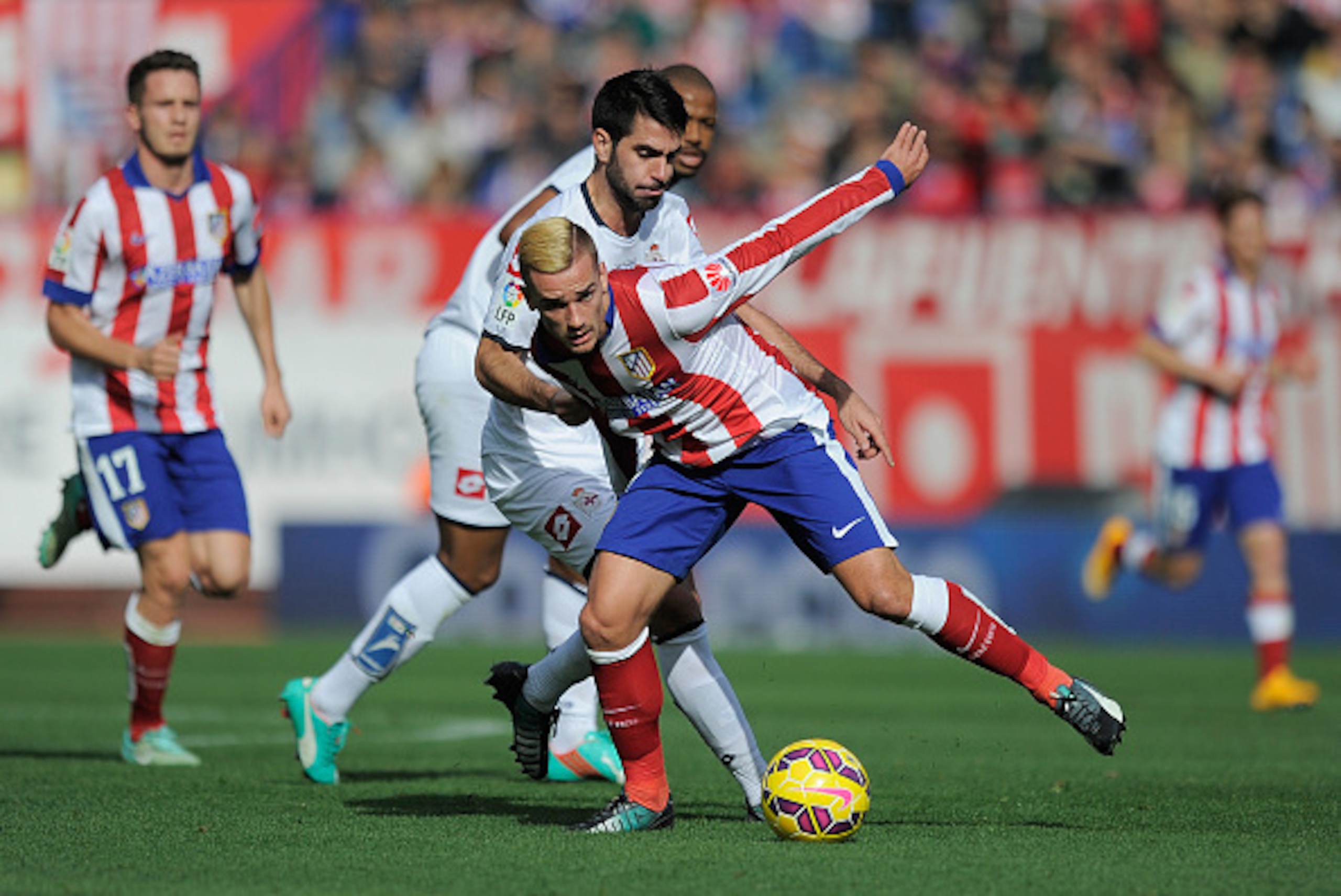 MADRID, SPAIN - NOVEMBER 30:    Antoine Griezmann of Club Atletico de Madrid is tackled by Pablo Insua of RC Deportivo La Coruna during the La Liga match between Club Atletico de Madrid and RC Deportivo La Coruna   at Vicente Calderon Stadium on November 