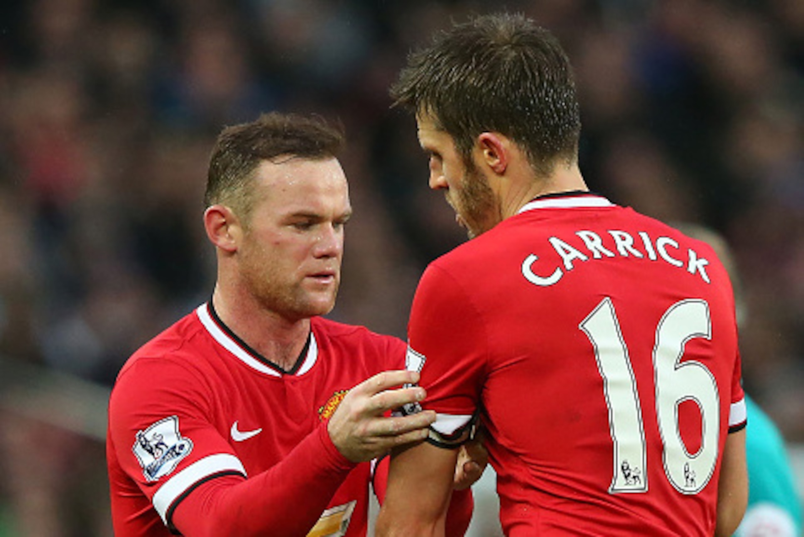MANCHESTER, ENGLAND - DECEMBER 14:  Wayne Rooney of Manchester United passes the Captain's armband to Michael Carrick during the Barclays Premier League match between Manchester United and Liverpool at Old Trafford on December 14, 2014 in Manchester, Engl