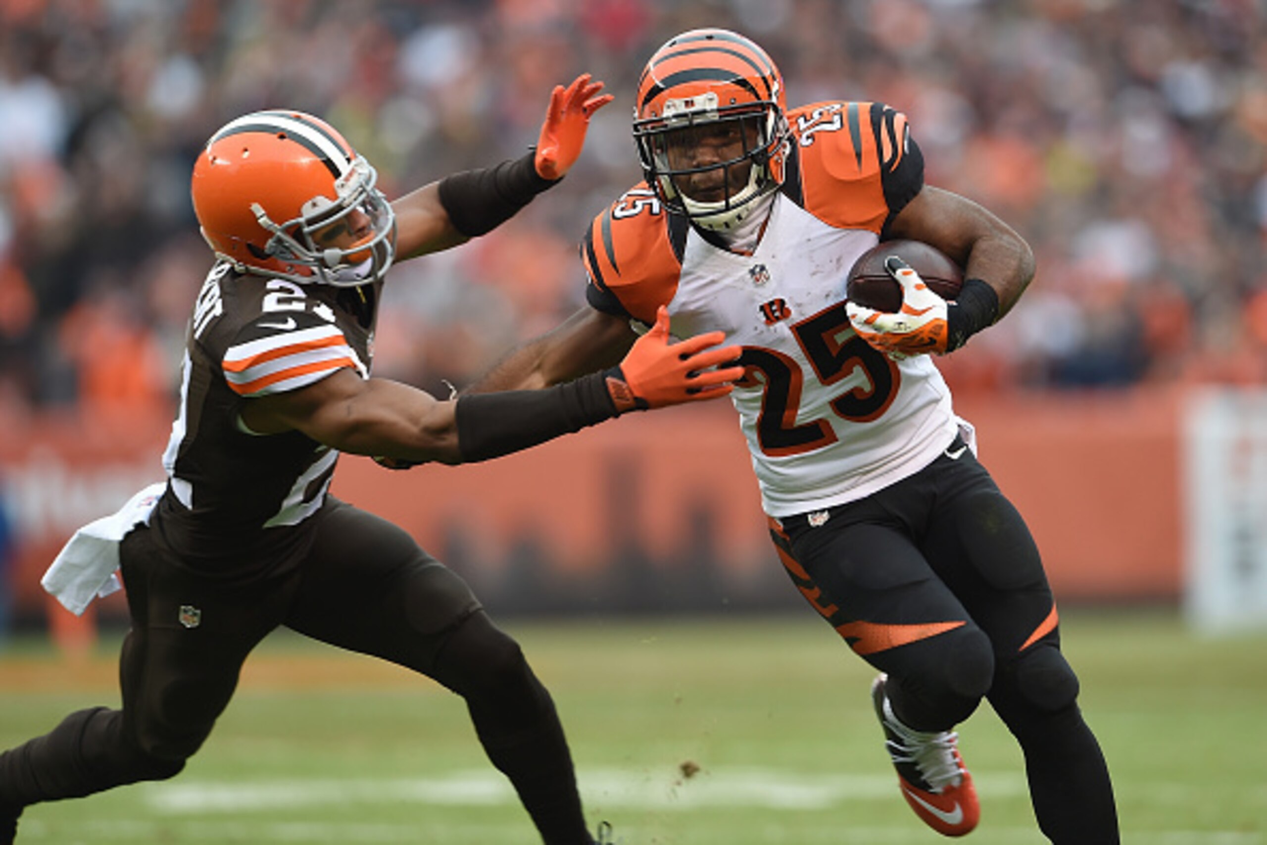 CLEVELAND, OH - DECEMBER 14:  Giovani Bernard #25 of the Cincinnati Bengals runs past the defense of Justin Gilbert #21 of the Cleveland Browns during the first quarter at FirstEnergy Stadium on December 14, 2014 in Cleveland, Ohio.  (Photo by Jason Mille