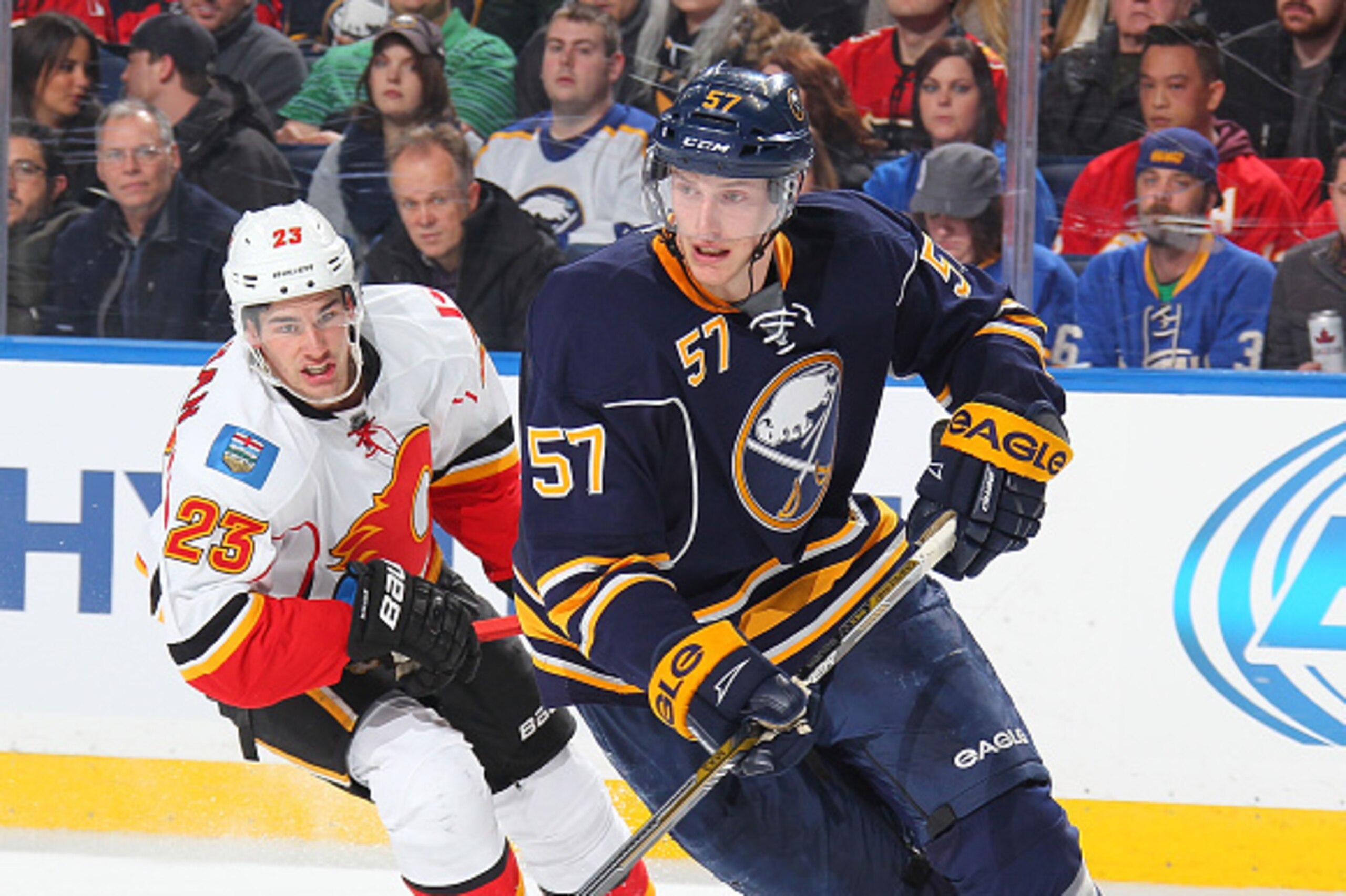 BUFFALO, NY - DECEMBER 11: Tyler Myers #57 of the Buffalo Sabres controls the puck against Sean Monahan #23 of the Calgary Flames on December 11, 2014 at the First Niagara Center in Buffalo, New York.  (Photo by Bill Wippert/NHLI via Getty Images)