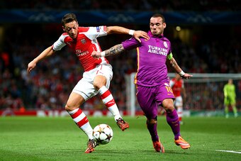 LONDON, ENGLAND - OCTOBER 01:  Mesut Oezil of Arsenal battles for tha ball with Wesley Sneijder of Galatasaray AS during the UEFA Champions League group D match between Arsenal FC and Galatasaray AS at Emirates Stadium on October 1, 2014 in London, United