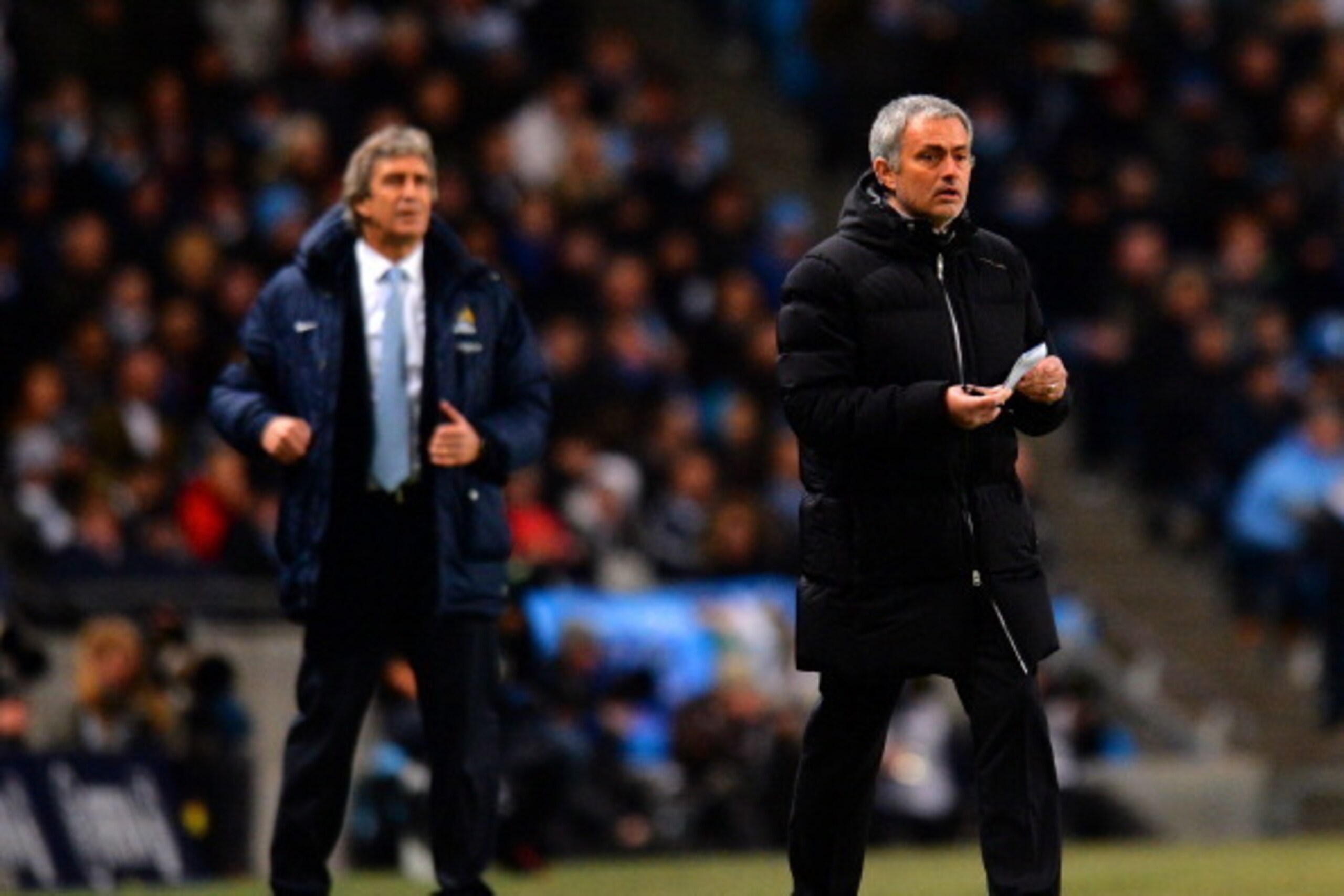 MANCHESTER, ENGLAND - FEBRUARY 03: Manuel Pellegrini manager of Manchester City and Jose Mourinho manager of Chelsea give instructions during the Barclays Premier League match between Manchester City and Chelsea at Etihad Stadium on February 3, 2014 in Ma