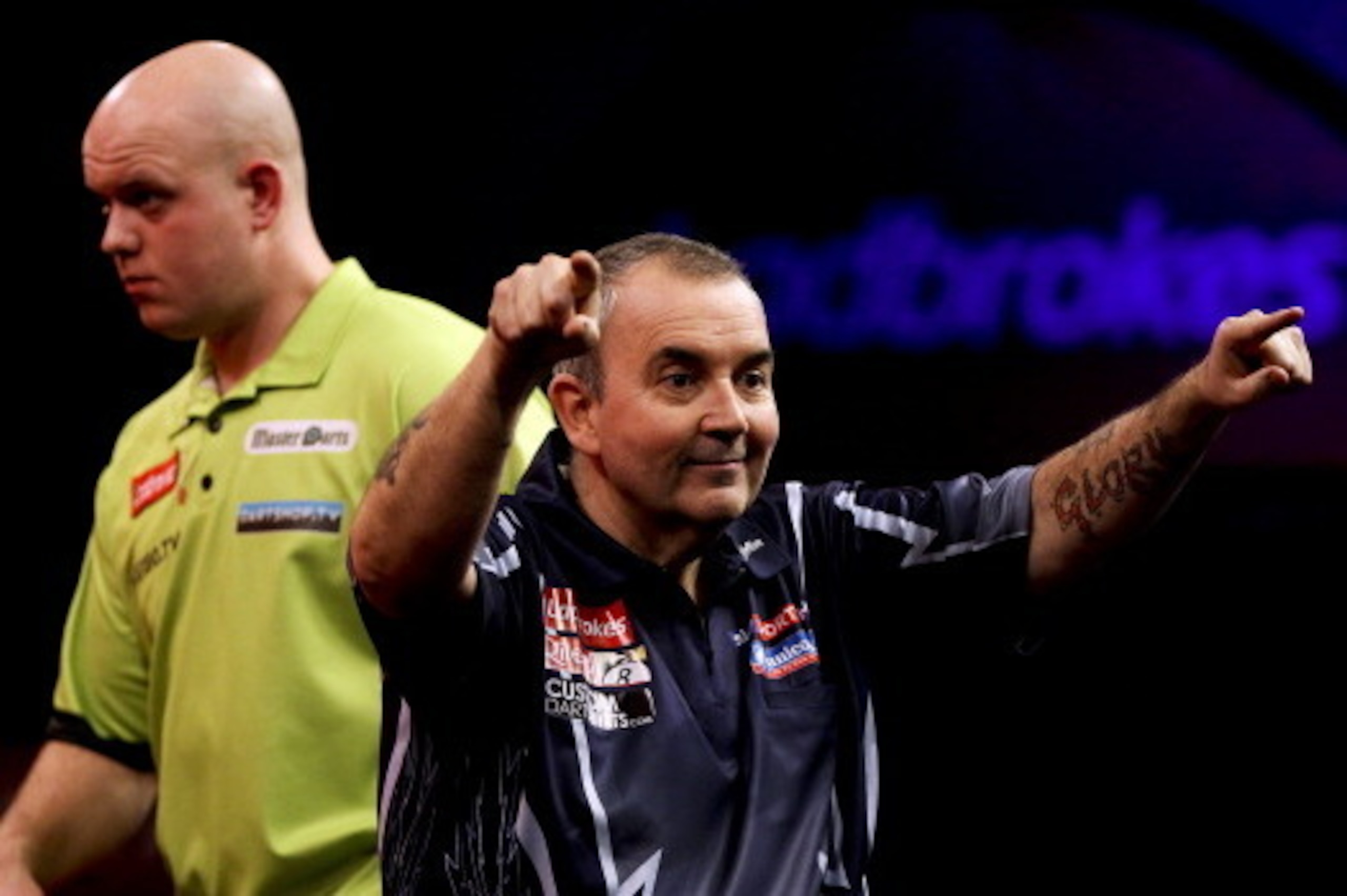 LONDON, ENGLAND - JANUARY 1: Phil Taylor celebrates winning the tenth set as Michael van Gerwen of the Netherlands looks on during the final of the 2013 Ladbrokes.com World Darts Championship at the Alexandra Palace on January 1, 2013 in London, England. 