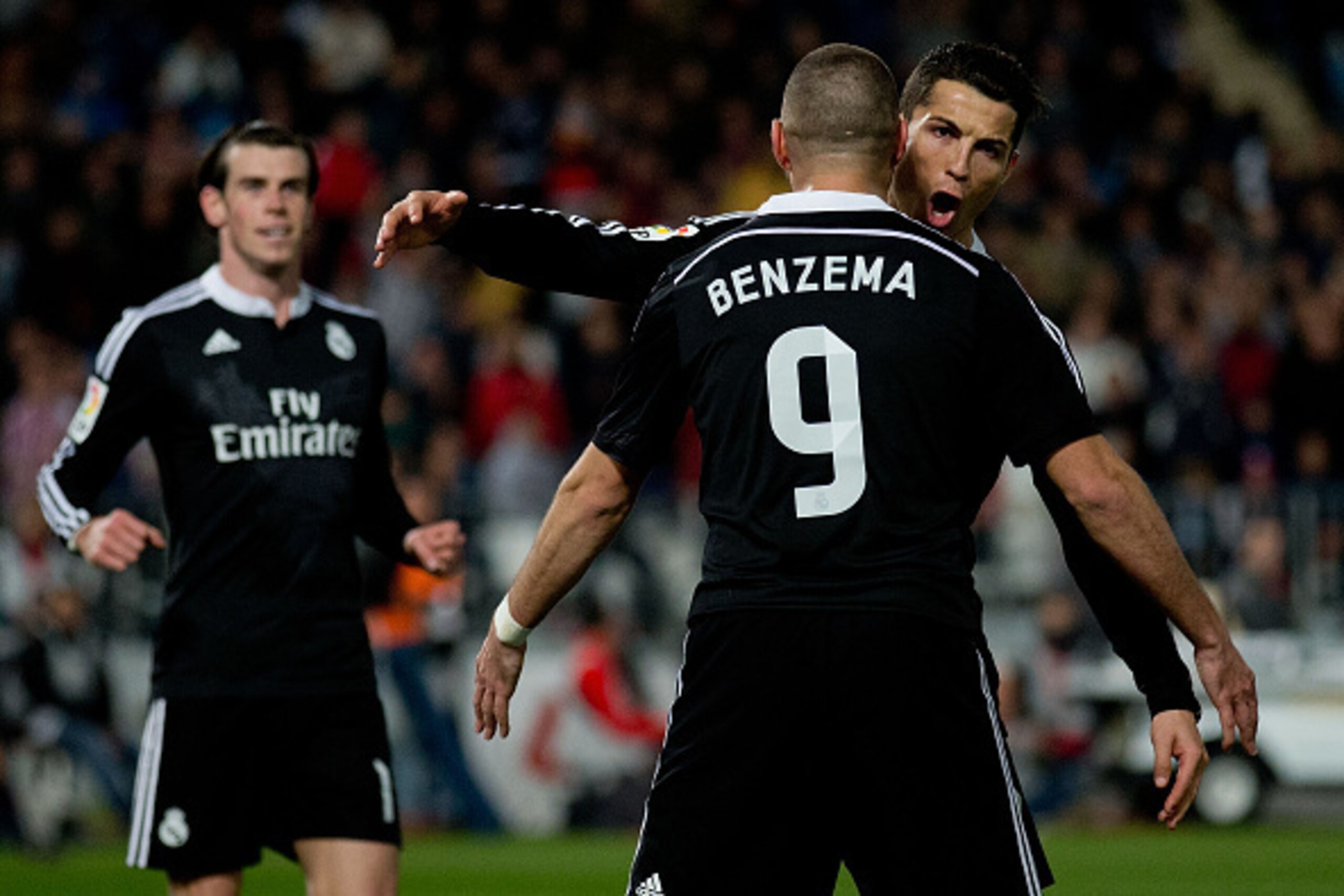 ALMERIA, SPAIN - DECEMBER 12:  Cristiano Ronaldo (R) of Real Madrid CF celebrates scoring their third goal with teammate Karim Benzema (L) as Gareth Bale (L) runs to them during the La Liga match between UD Almeria and Real Madrid CF at Juegos del Mediter