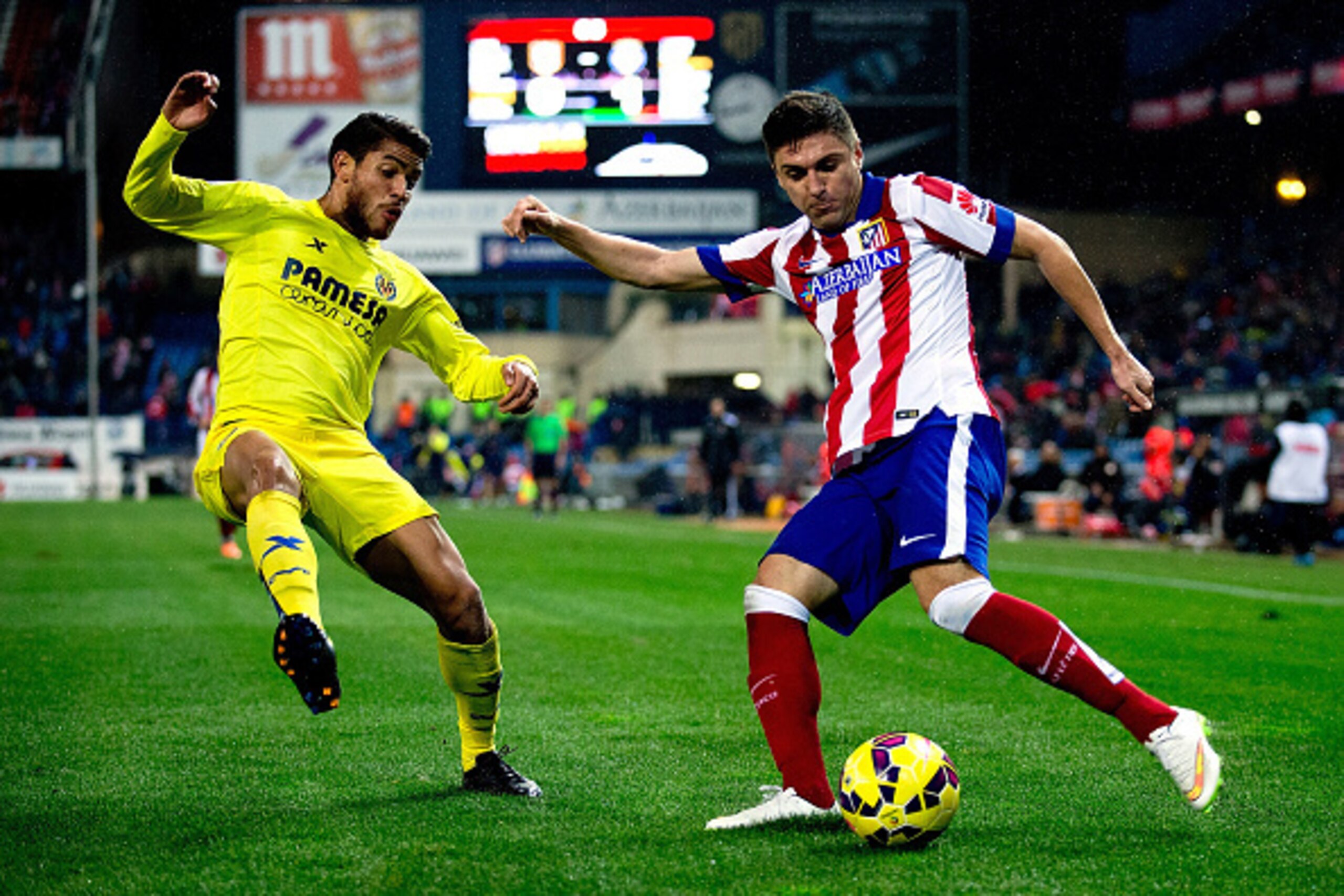 MADRID, SPAIN - DECEMBER 14: Guilherme Madalena Siqueira (R) competes for the ball with J. Dos Santos (L) of Villarreal CF during the La Liga match between Club Atletico de Madrid and Villarreal CF at Vicente Calderon Stadium on December 14, 2014 in Madri