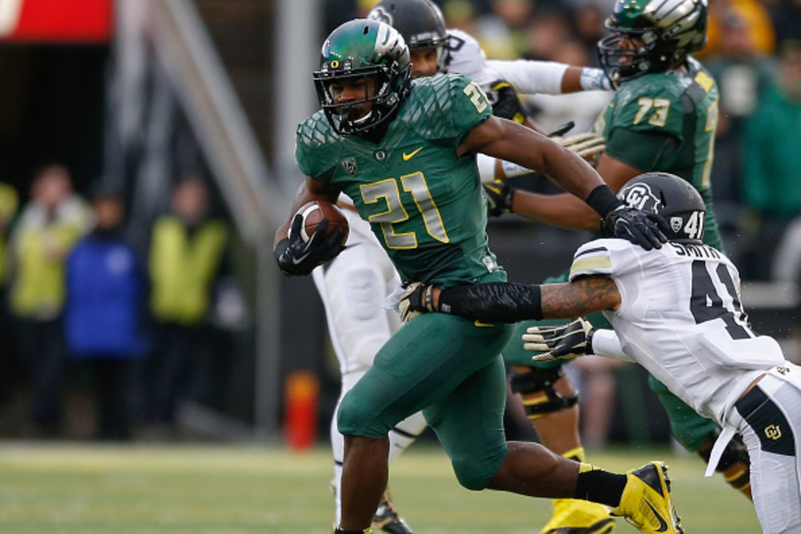 EUGENE, OR - NOVEMBER 22:  Running back Royce Freeman #21 of the Oregon Ducks rushes against defensive back Terrel Smith #41 of the Colorado Buffaloes at Autzen Stadium on November 22, 2014 in Eugene, Oregon.  (Photo by Otto Greule Jr/Getty Images)