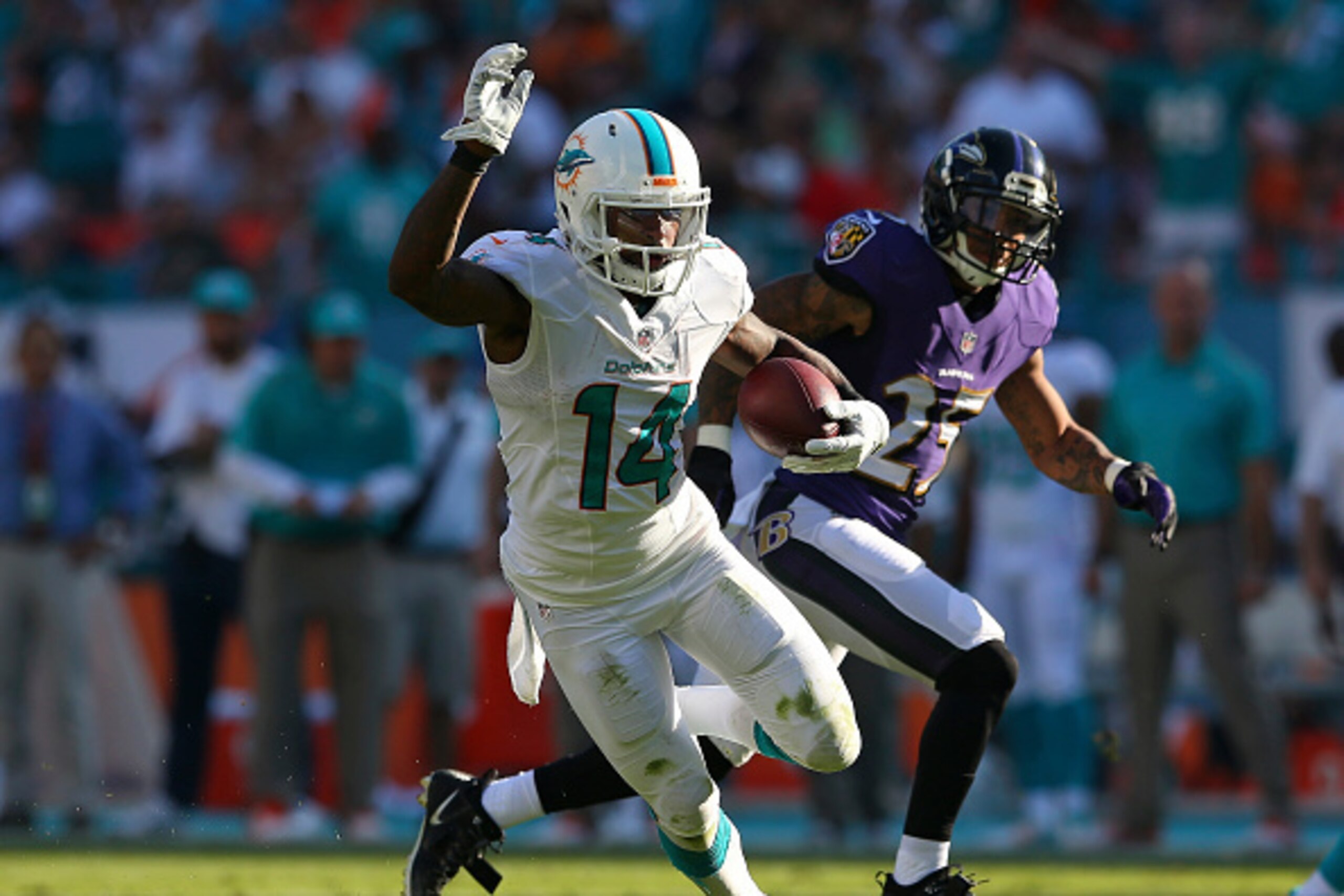 MIAMI GARDENS, FL - DECEMBER 07:  Wide receiver Jarvis Landry #14 of the Miami Dolphins picks up second-half yardage as cornerback Asa Jackson #25 of the Baltimore Ravens pursues during a game at Sun Life Stadium on December 7, 2014 in Miami Gardens, Flor