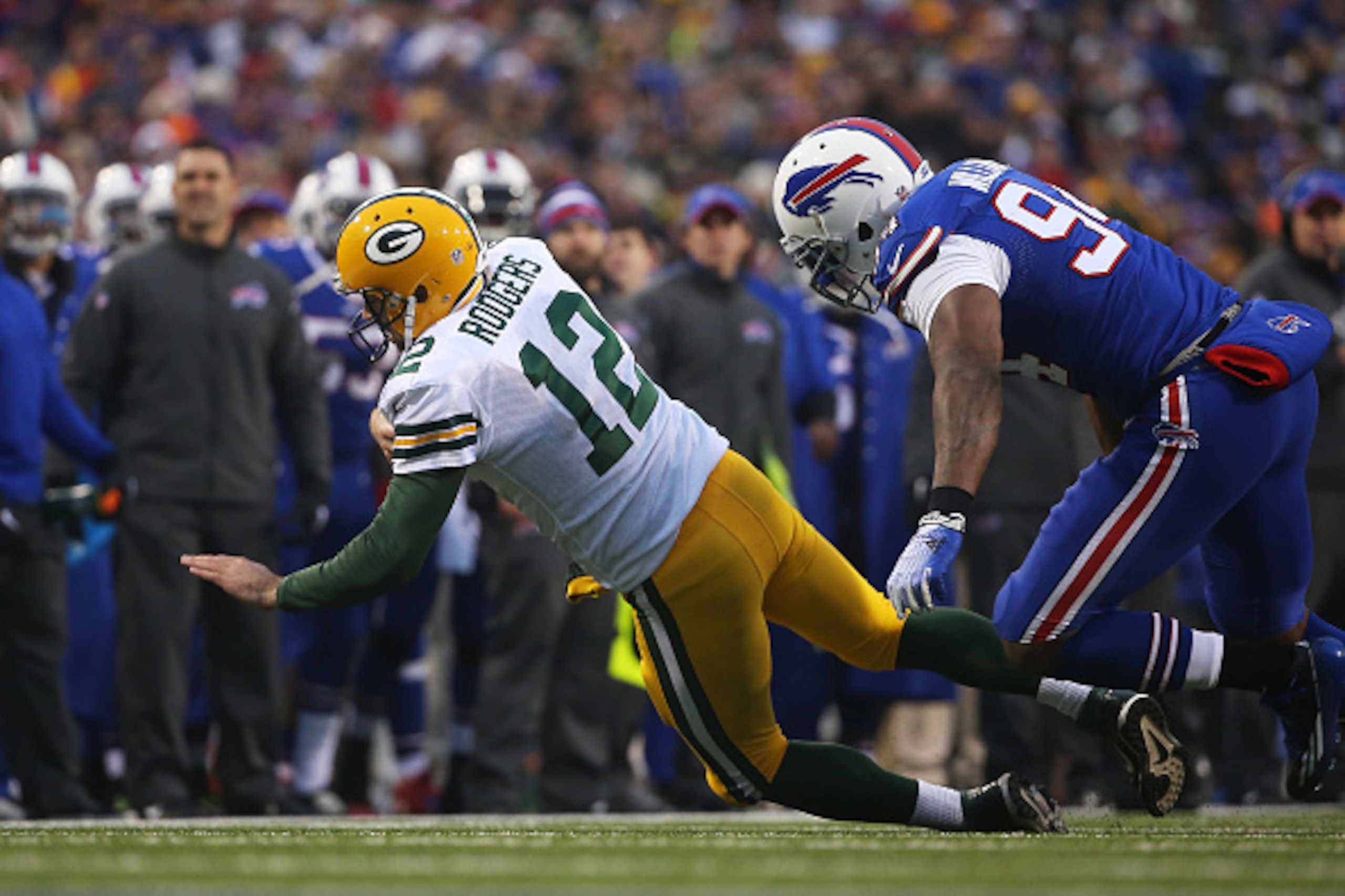 ORCHARD PARK, NY - DECEMBER 14:   Aaron Rodgers #12 of the Green Bay Packers is chased out of the pocket by Mario Williams #94 of the Buffalo Bills during the second half at Ralph Wilson Stadium on December 14, 2014 in Orchard Park, New York.  (Photo by T