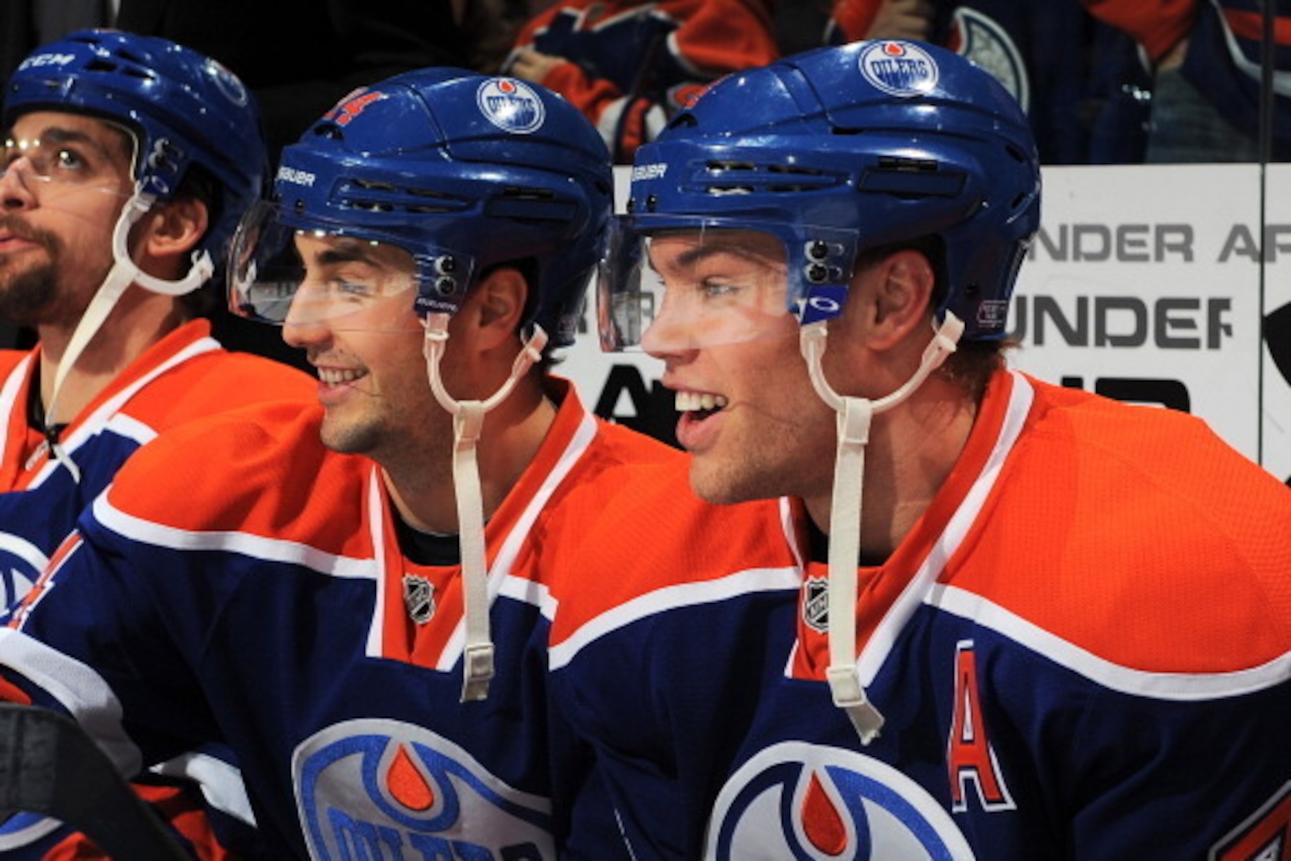 EDMONTON, AB - JANUARY 7: Jordan Eberle #14 and Taylor Hall #4 of the Edmonton Oilers smile as they watch from the bench prior to a game against the St. Louis Blues on January 7, 2014 at Rexall Place in Edmonton, Alberta, Canada. (Photo by Andy Devlin/NHL